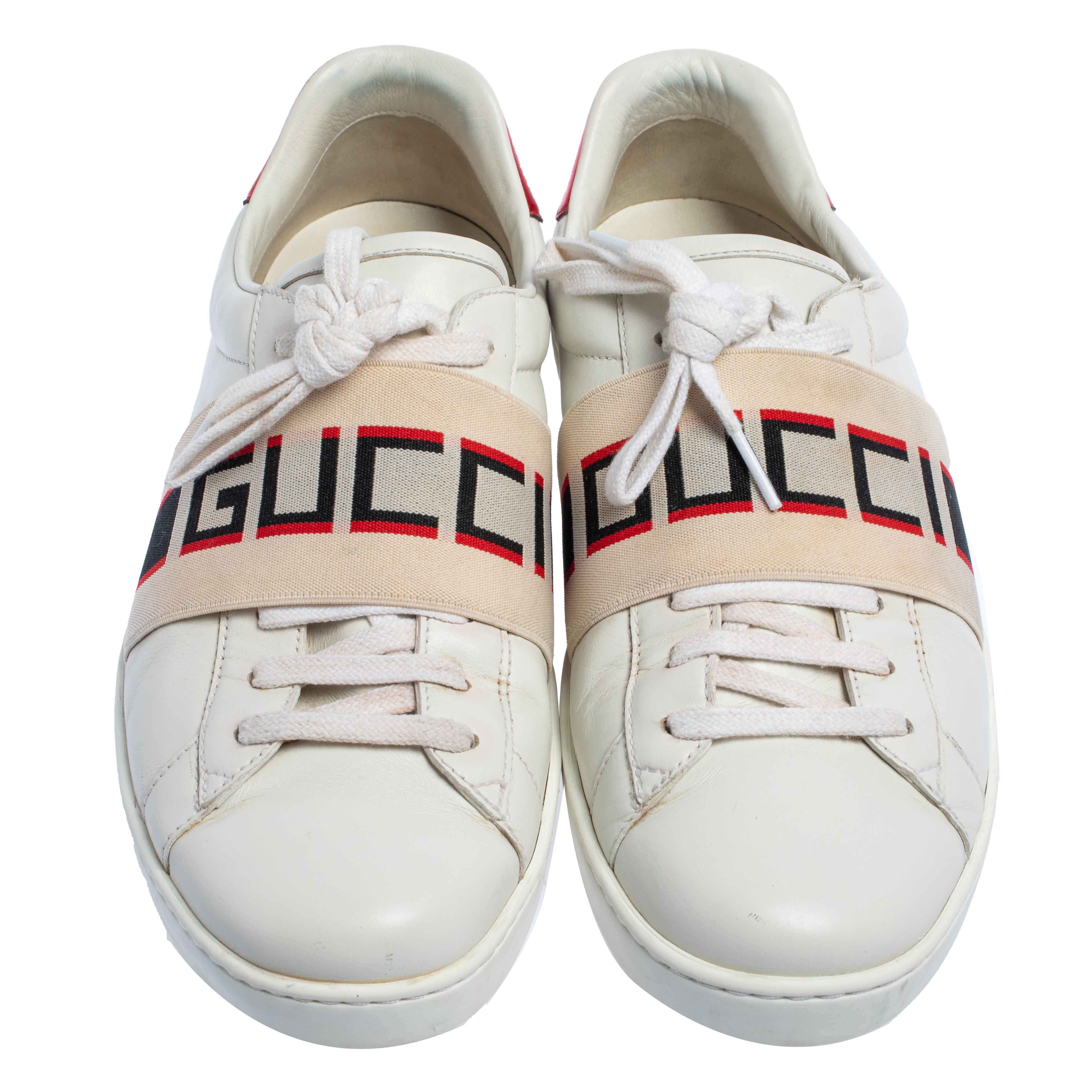 Stacked with signature details, this Gucci pair is rendered in white and red leather and is designed in a low-cut style with lace-ups. The sneakers have been fashioned with 'GUCCI' bands on the vamps. Complete with red trims carrying the brand label