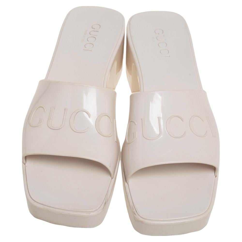 Made in Italy, these fun Gucci slides are a playful take on a staple style. Crafted from rubber, the slides feature the embossed Gucci logo, open toes, and chunky heels. The white pair projects a retro appeal along with being water-resistant.

