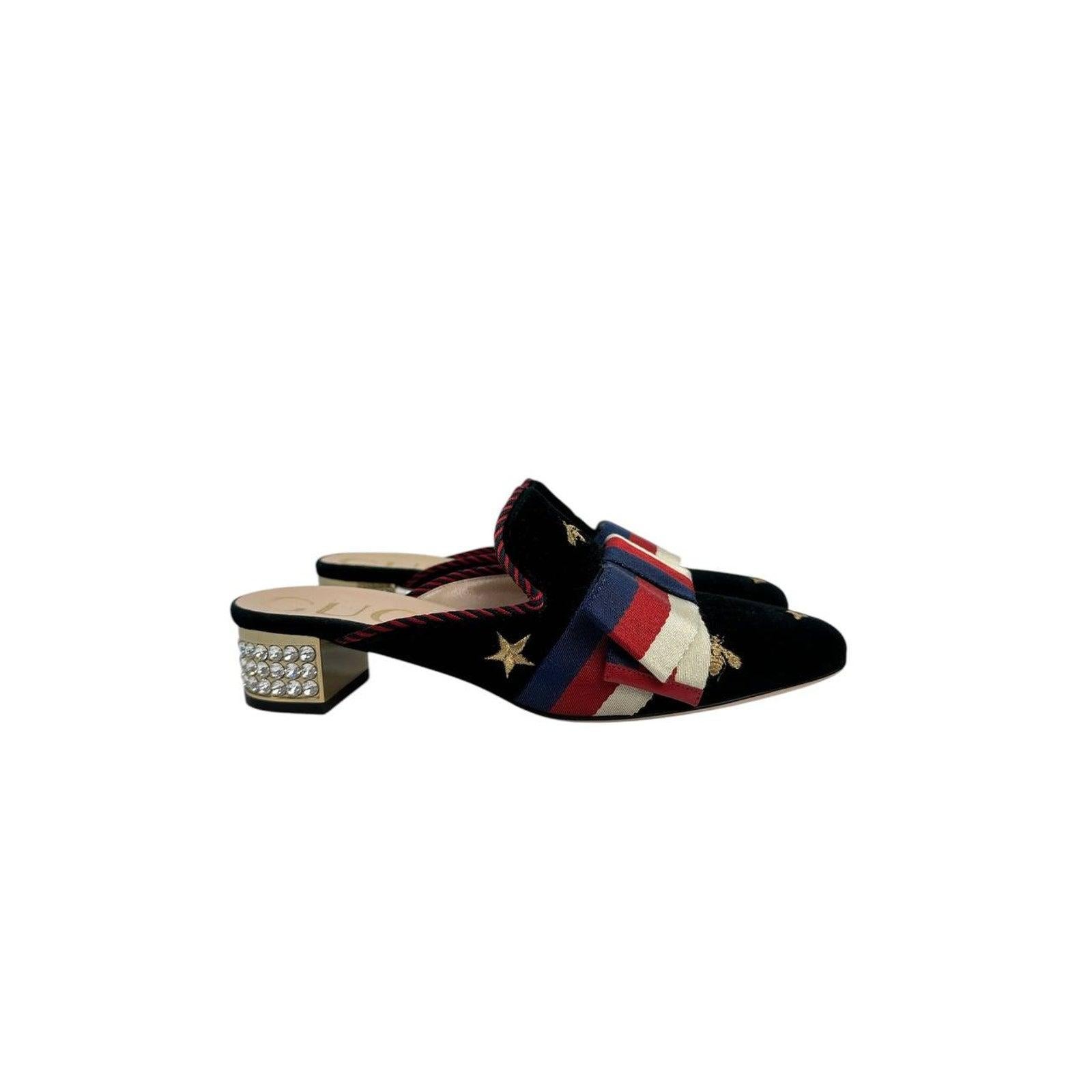 Esci con stile con queste splendide mules in velluto di Gucci! Queste scarpe combinano sapientemente una lavorazione audace con elementi visivi accattivanti.

Il velluto nero profondo fa da sfondo alle stelle ricamate e al fiocco in tessuto in stile