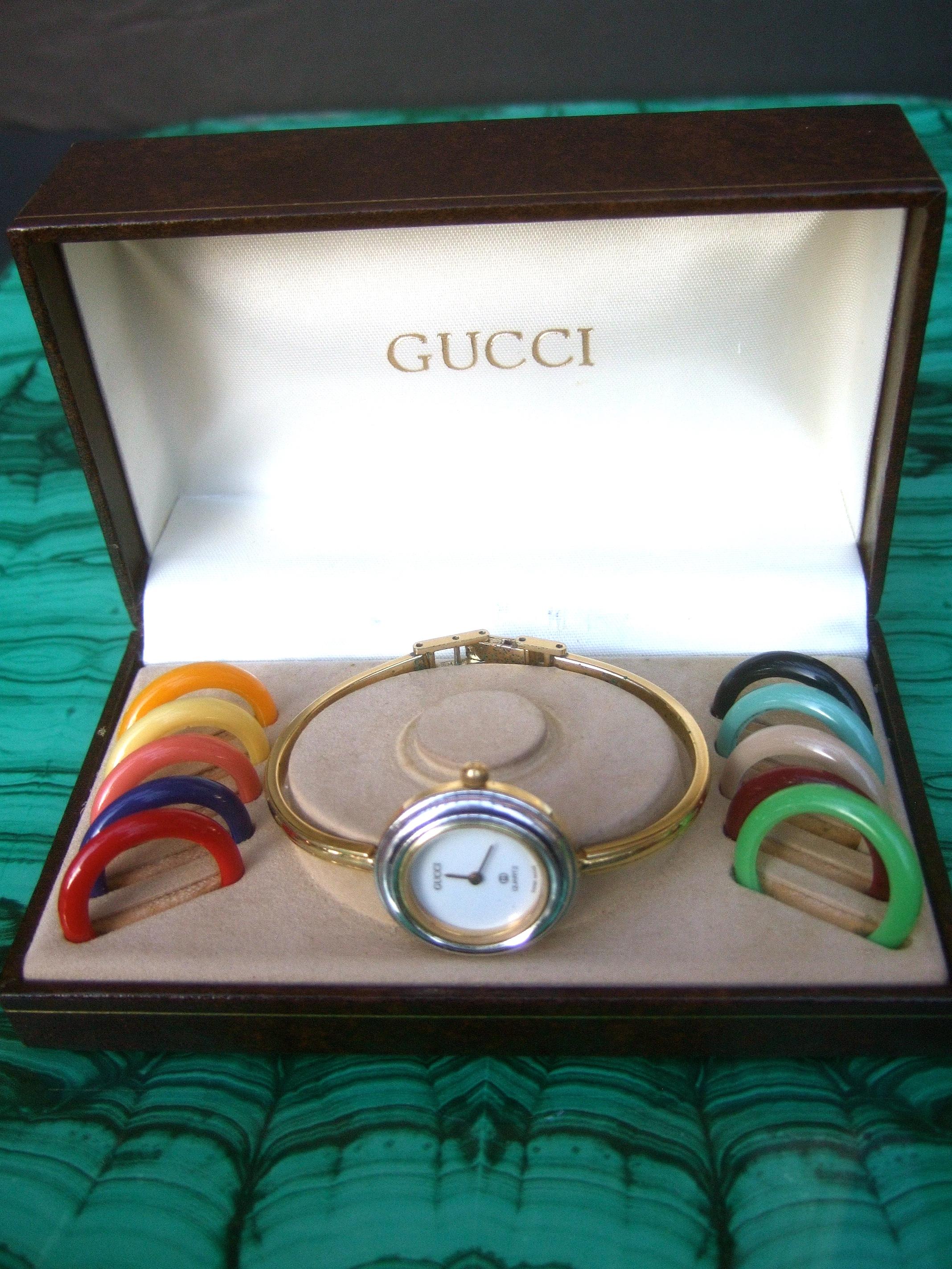 Gucci women's wrist in original Gucci presentation box c 1980s
The stylish wrist watch is designed with ten plastic resin interchangeable 
circular dial rings in a myriad of colors. It too may be worn with the silver
and gold tone circular dial