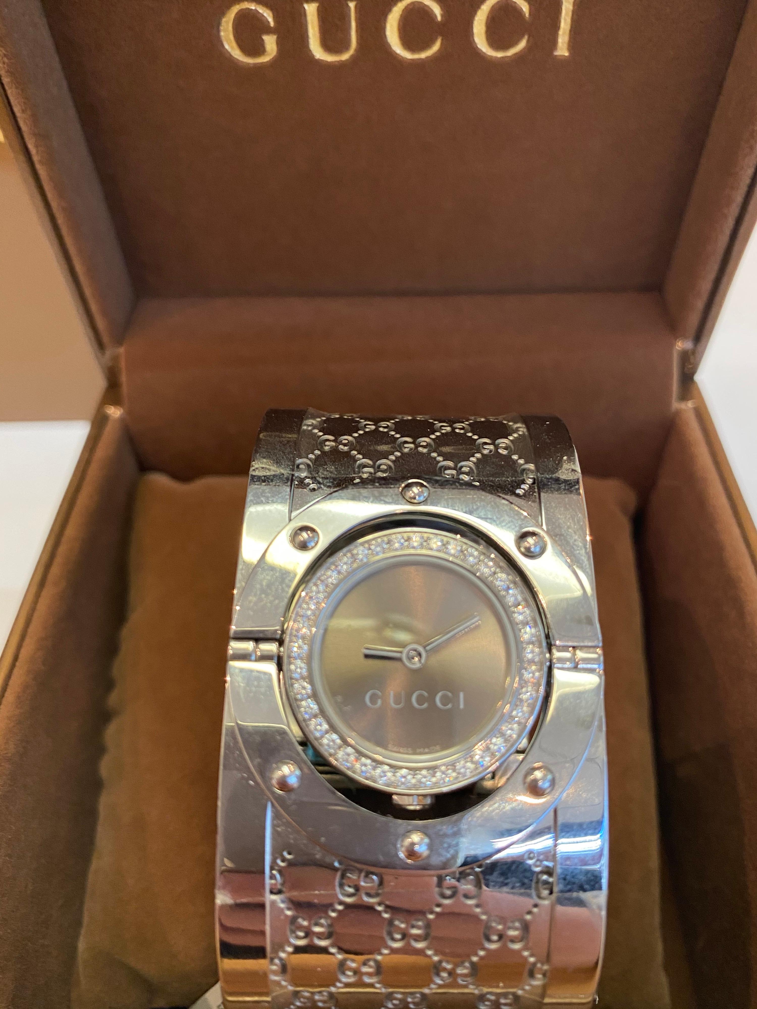 New with tags GUCCI Women's YA112416 Twirl Watch with Brown Dial and diamond bezel, diamonds weighting in total 2.60 carats:

Quartz movement
Scratch resistant sapphire crystal
Case diameter:23 mm
Stainless steel case
Women's Band width: 33