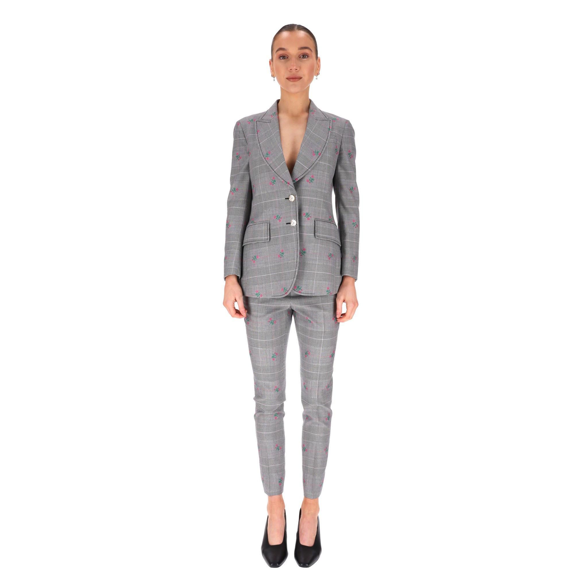 Gucci Wool Checked Floral Jacket & Trousers Suit

Grey suit crafted from wool in prince of Wales check pattern with tiny embroidered flowers in pink with green stems and leaves.

Single-breasted blazer with notched lapels and flap pockets to the
