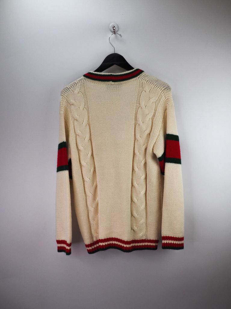 This piece is made with quality wool and designed as a cardigan. Featuring a cream wool cardigan with two external pockets, buttoned closure, signature web stripes, front buttons and long sleeves. 

COLOR: Cream with green and red stripes.
MATERIAL: