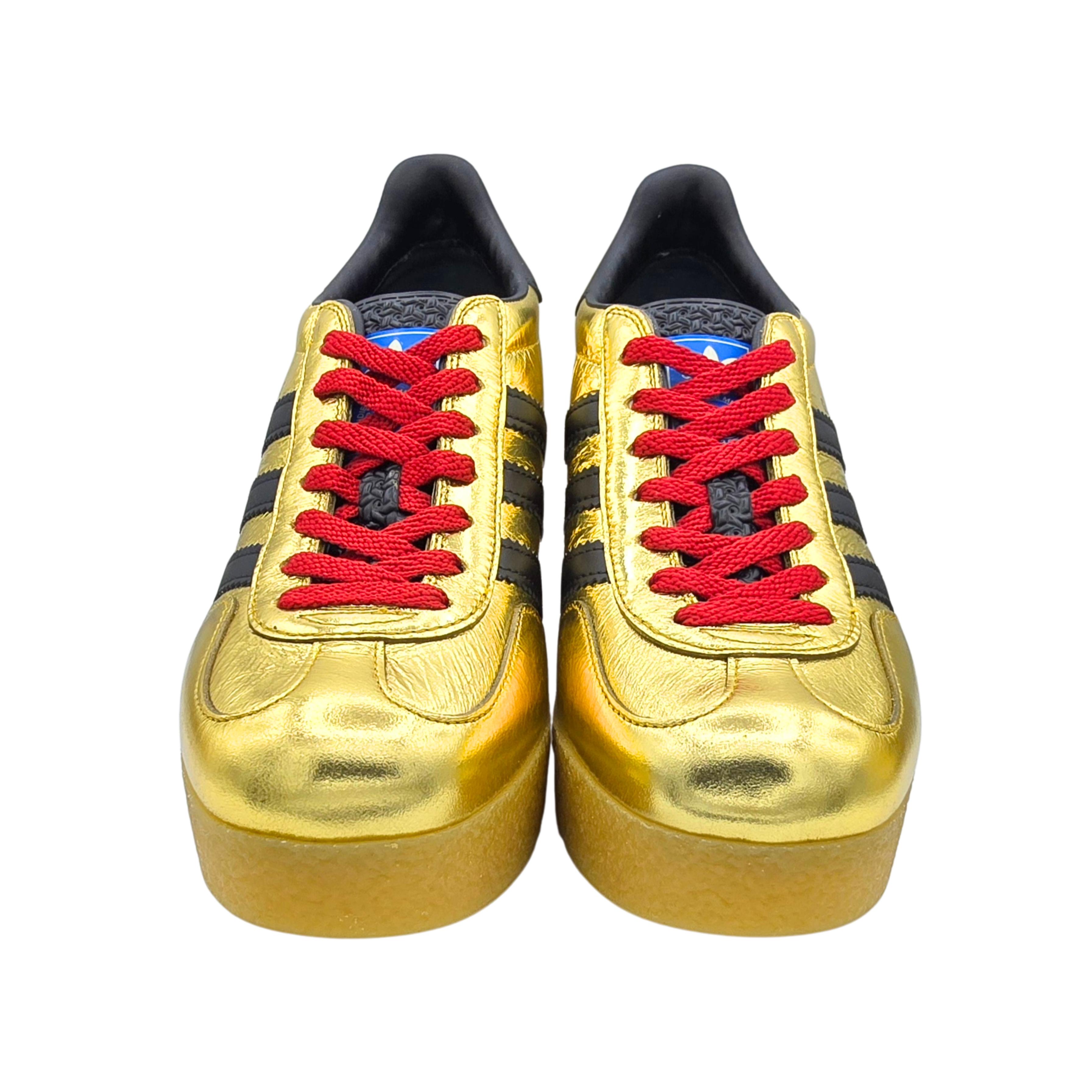 This is from the sold out collection of Gucci x Adidas.  This is an authentic, brand new 650pair of Gucci x Adidas Ginza Calfskin Demetra Gazelle Wedge Sneakers in metallic gold with black Adidas stripes and trim and red laces.

It features a rubber