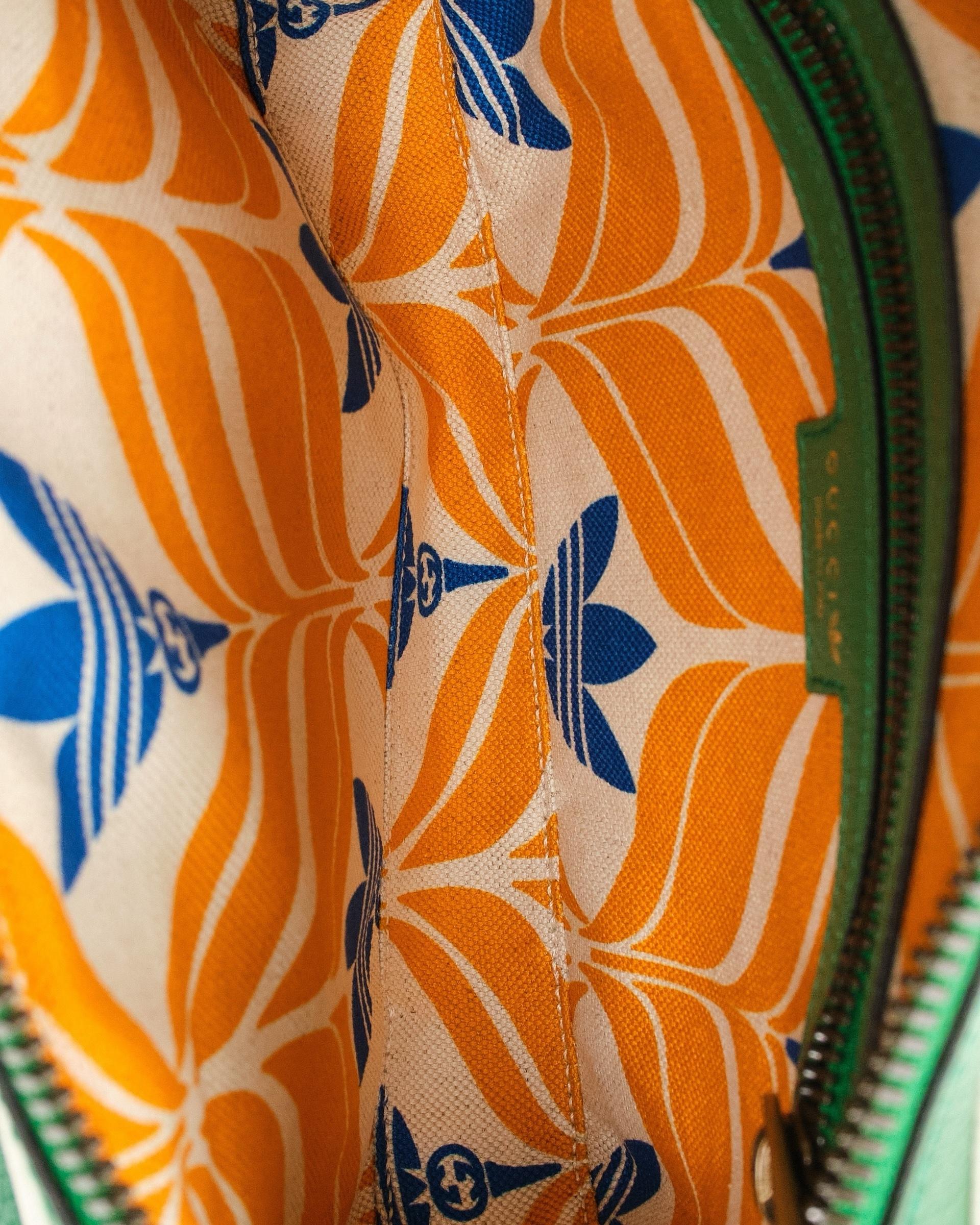 Die charakteristische Gürteltasche von Gucci in Zusammenarbeit mit Adidas, Modell Trefoil, aus Leder in Grün mit Einsätzen  weiße und goldene Hardware. Ausgestattet mit einem Reißverschluss an der Oberseite, innen mit mehrfarbigem Segeltuch