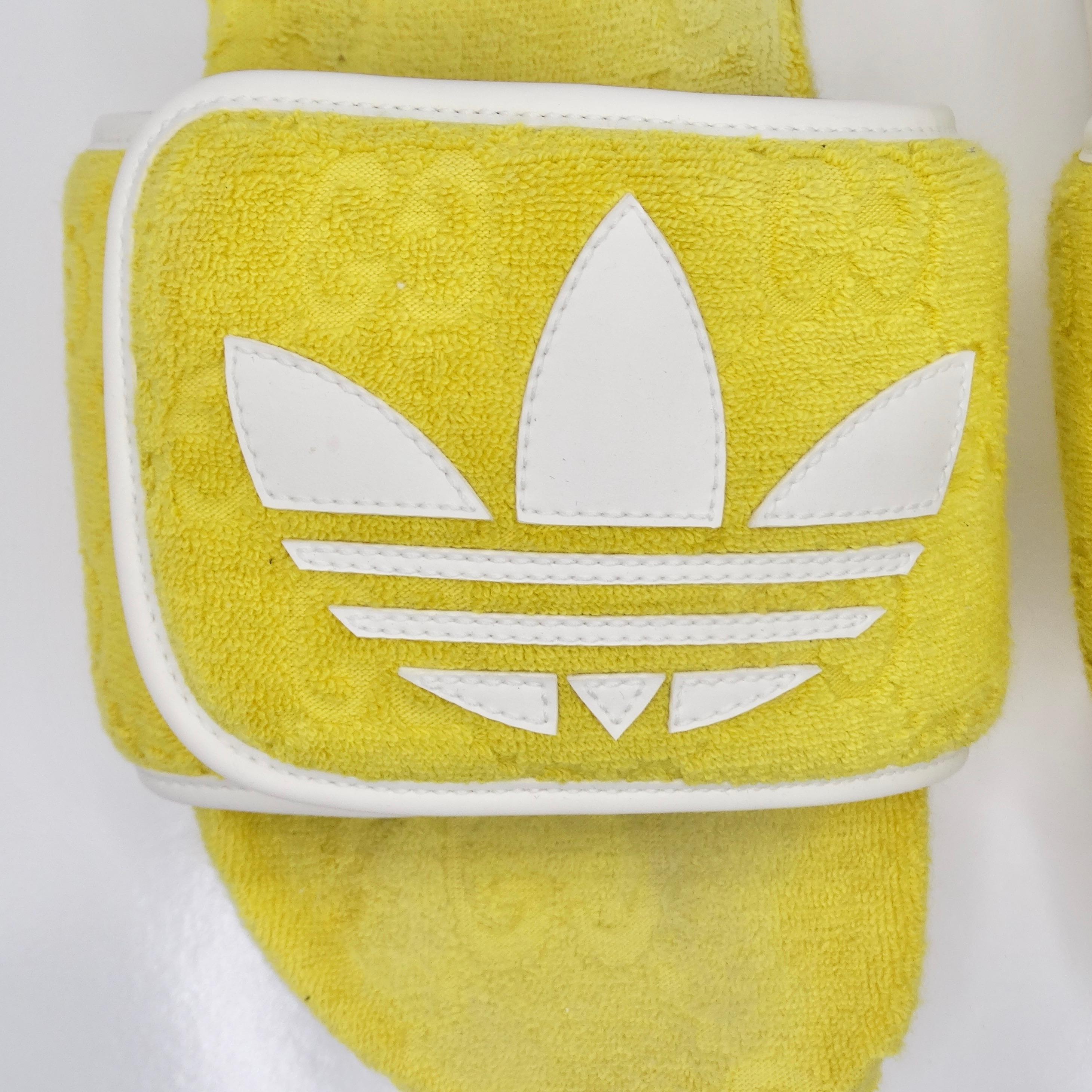 Voici les Gucci X Adidas Yellow Terry Cloth GG Monogram Platform Sandals - une collaboration vibrante et élégante qui associe l'emblématique monogramme Gucci GG à l'esthétique sportive d'Adidas. Fabriquées en tissu éponge doux dans une teinte jaune