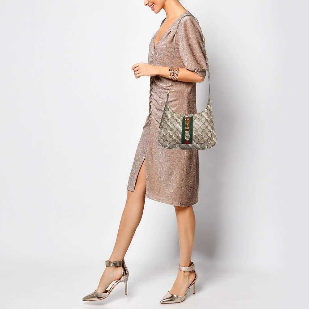 The Gucci x Balenciaga Jackie 1961 Hobo combines heritage with modern flair in beige/brown GG Supreme canvas. This limited edition piece reimagines the iconic silhouette showcasing a blend of Guccis timeless design and Balenciagas contemporary edge.