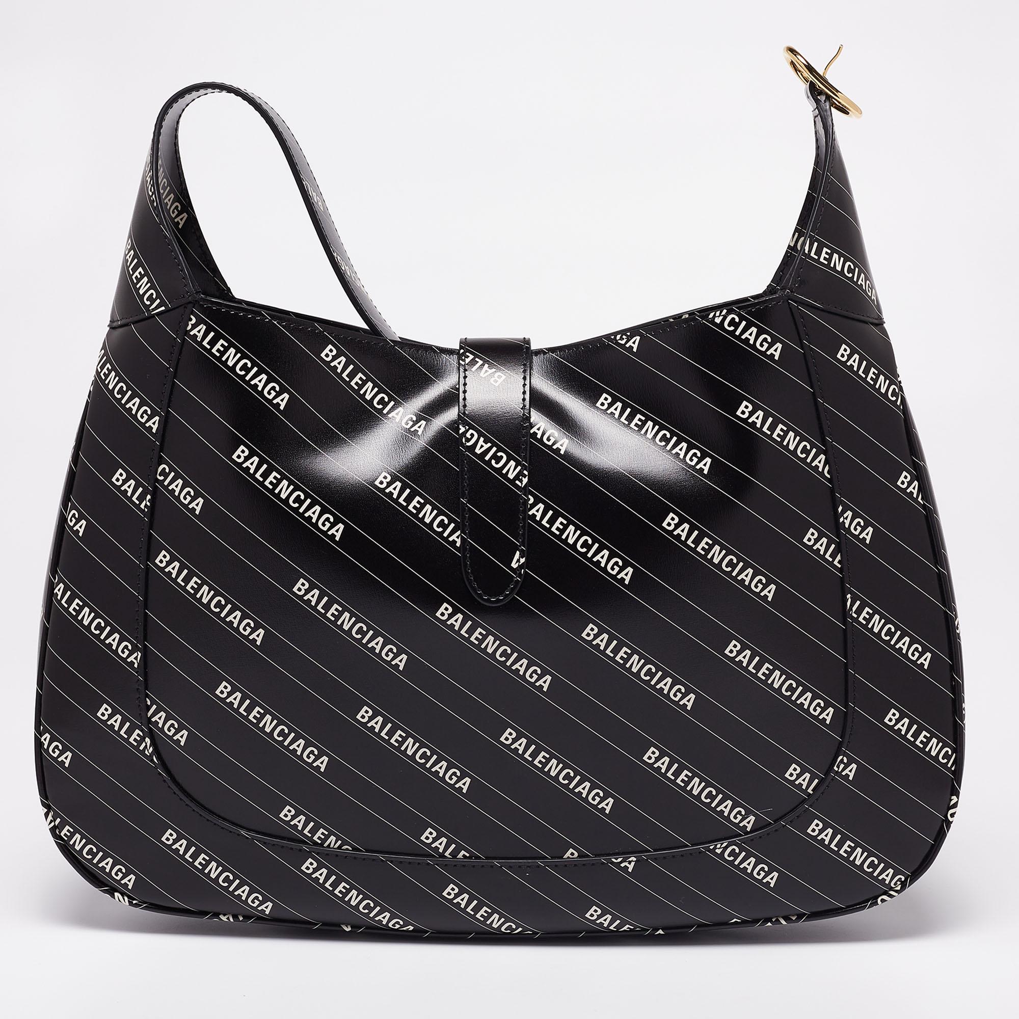 Shaped into a distinctively unique silhouette, this Jackie hobo from Gucci x Balenciaga will forever remain an iconic creation that will leave an imprint on your mind. It is made from black logo-printed leather, with the signature lock closure