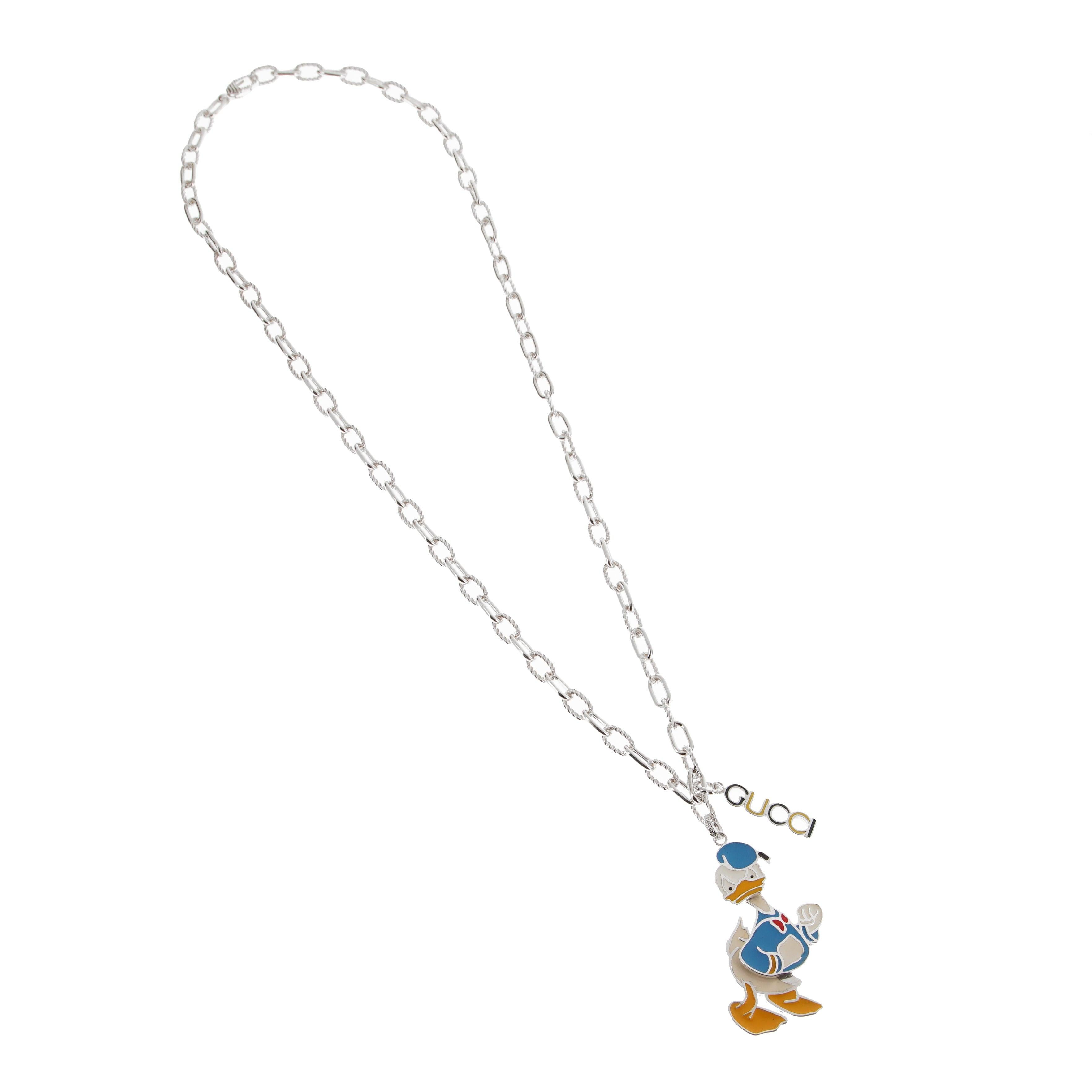 Introducing the Gucci x Disney Donald Duck Pendant Necklace, a striking blend of pop culture and high fashion that exemplifies the artistry of luxury jewelry design.

Crafted from polished sterling silver, this necklace features a vibrant enamel