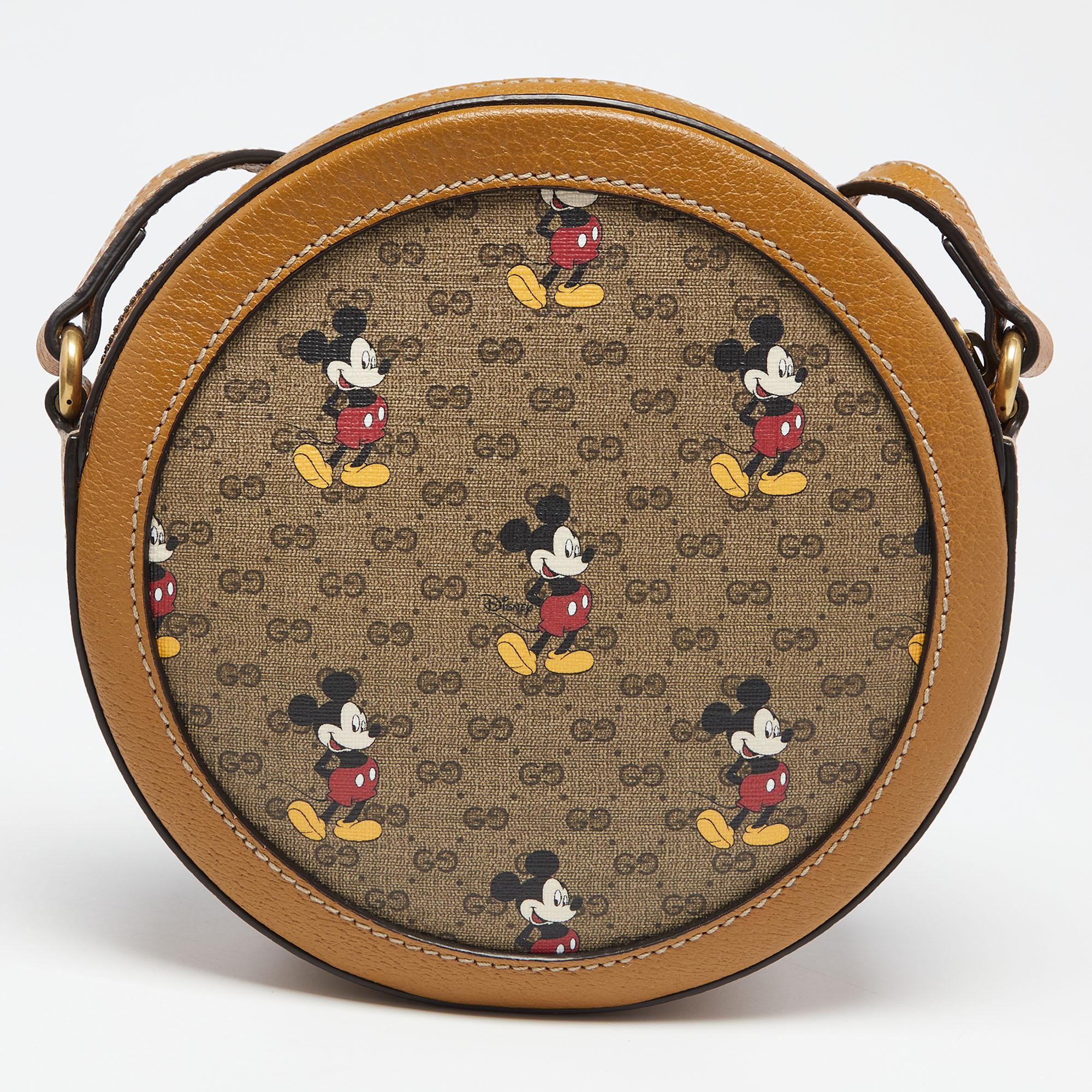 This Mickey Mouse crossbody bag is from the Gucci x Disney collaboration. Crafted using GG Supreme canvas and leather, the bag has a round shape, a shoulder strap, and a canvas-lined interior. The cute prints and the GG detail add to the overall