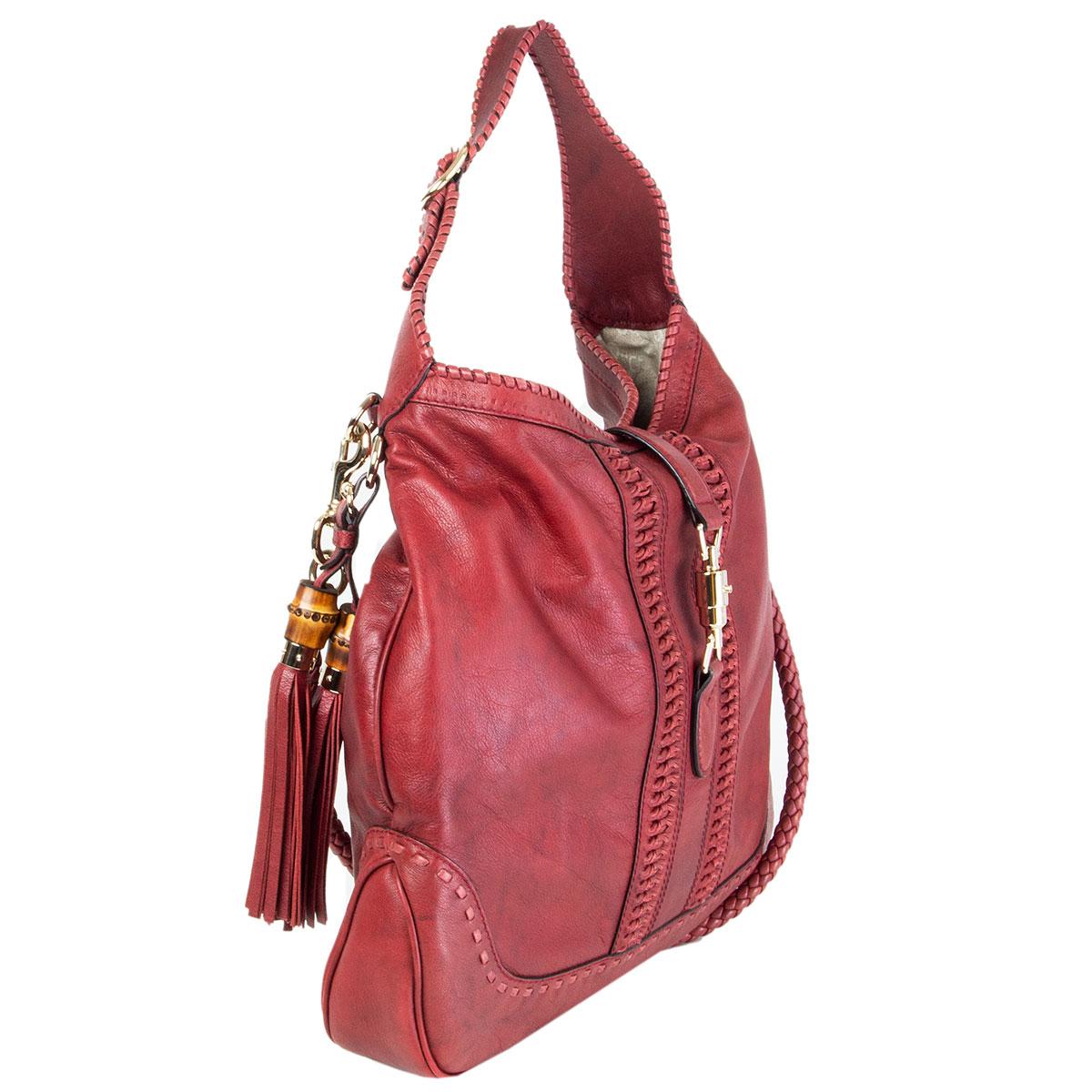authentic Gucci x Green Carpet Challenge 'New Jackie Large' hobo in burgundy distressed calfskin featuring light gold-tone hardware. Lined in off-white canvas with one zipper pocket against the back and two small open pockets against the front.