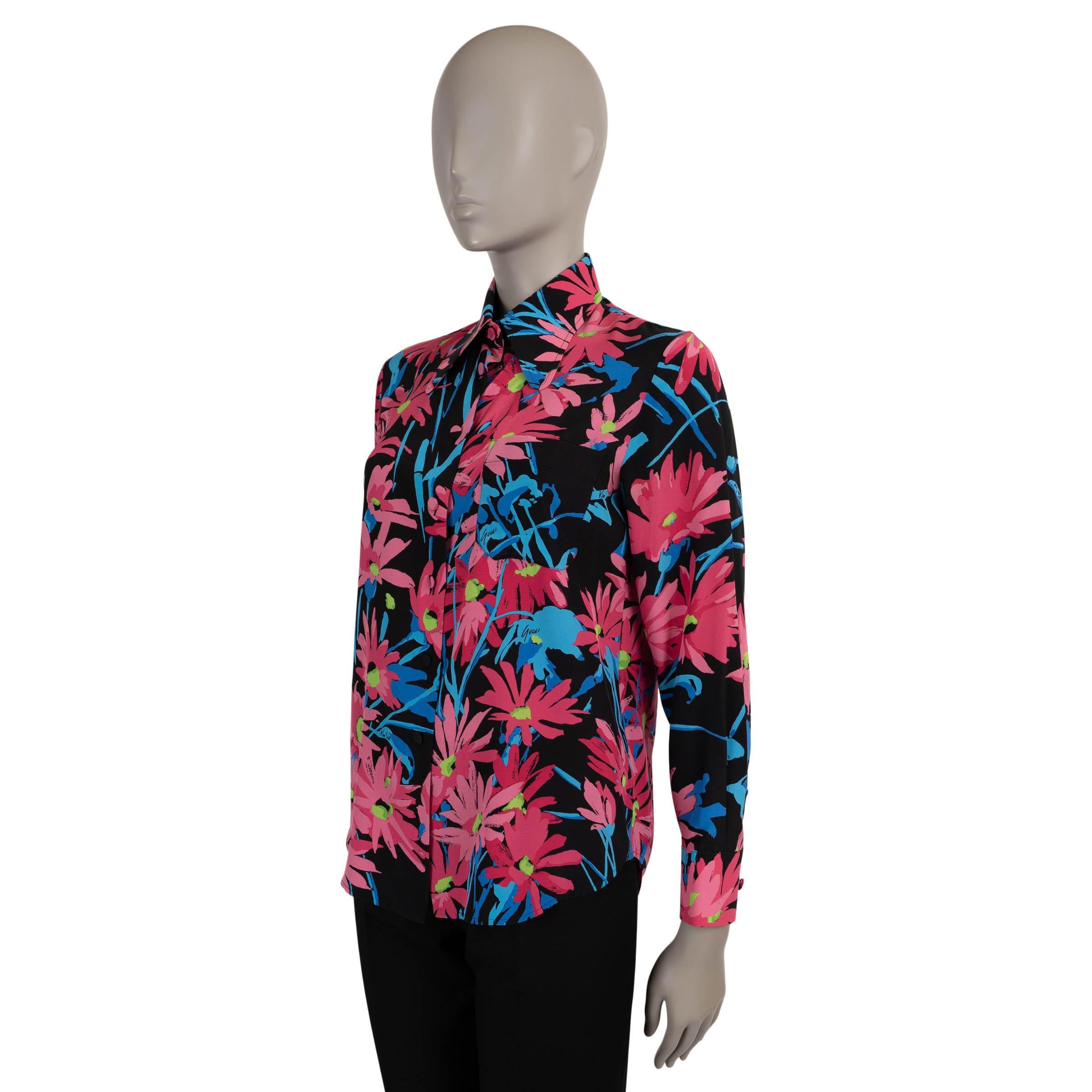 This 100% authentic Gucci x Ken Scott blouse is crafted in midnight blue silk and adorned with a vibrant floral print in shades of blue and pink. Designed with a fitted silhouette, it features a bold retro collar, a single chest patch pocket, and