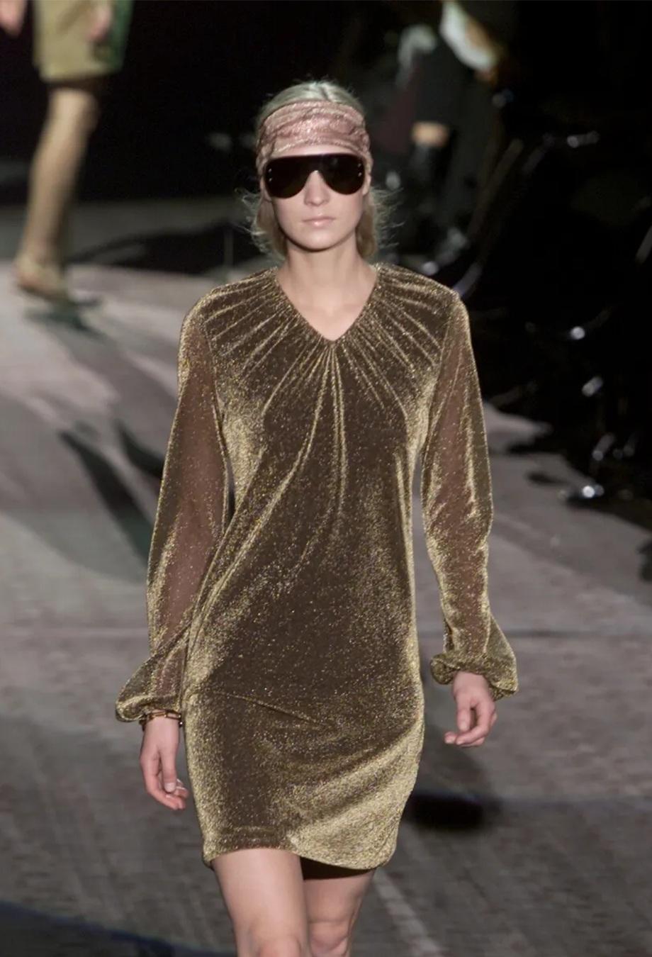 Mini version of look #29 from Tom Fords Fall 2000 collection for Gucci. Made from glittery gold knit lamé, this mini dress features a v-neckline and balloon sleeves. Own a piece of fashion history with this rare item. 

Made in Italy
Archival runway