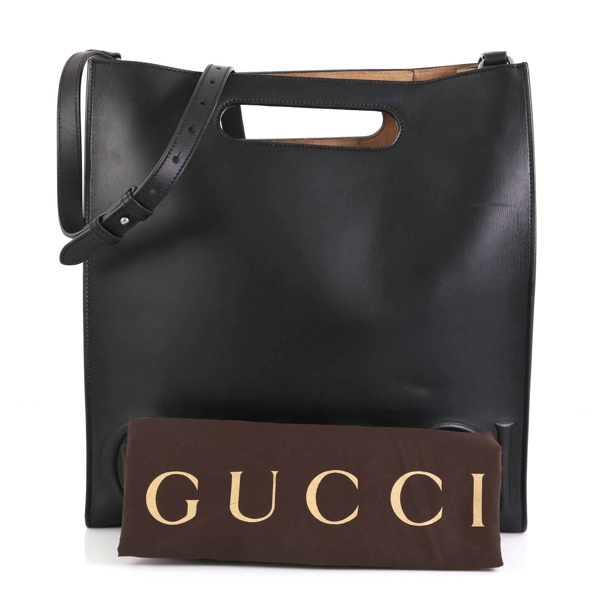 This Gucci XL Tote Leather Large, crafted from black leather, features an adjustable shoulder strap, embossed Gucci logo that extends across the front of the bag, hand-painted edges, and aged silver-tone hardware. Its wide open top showcases a