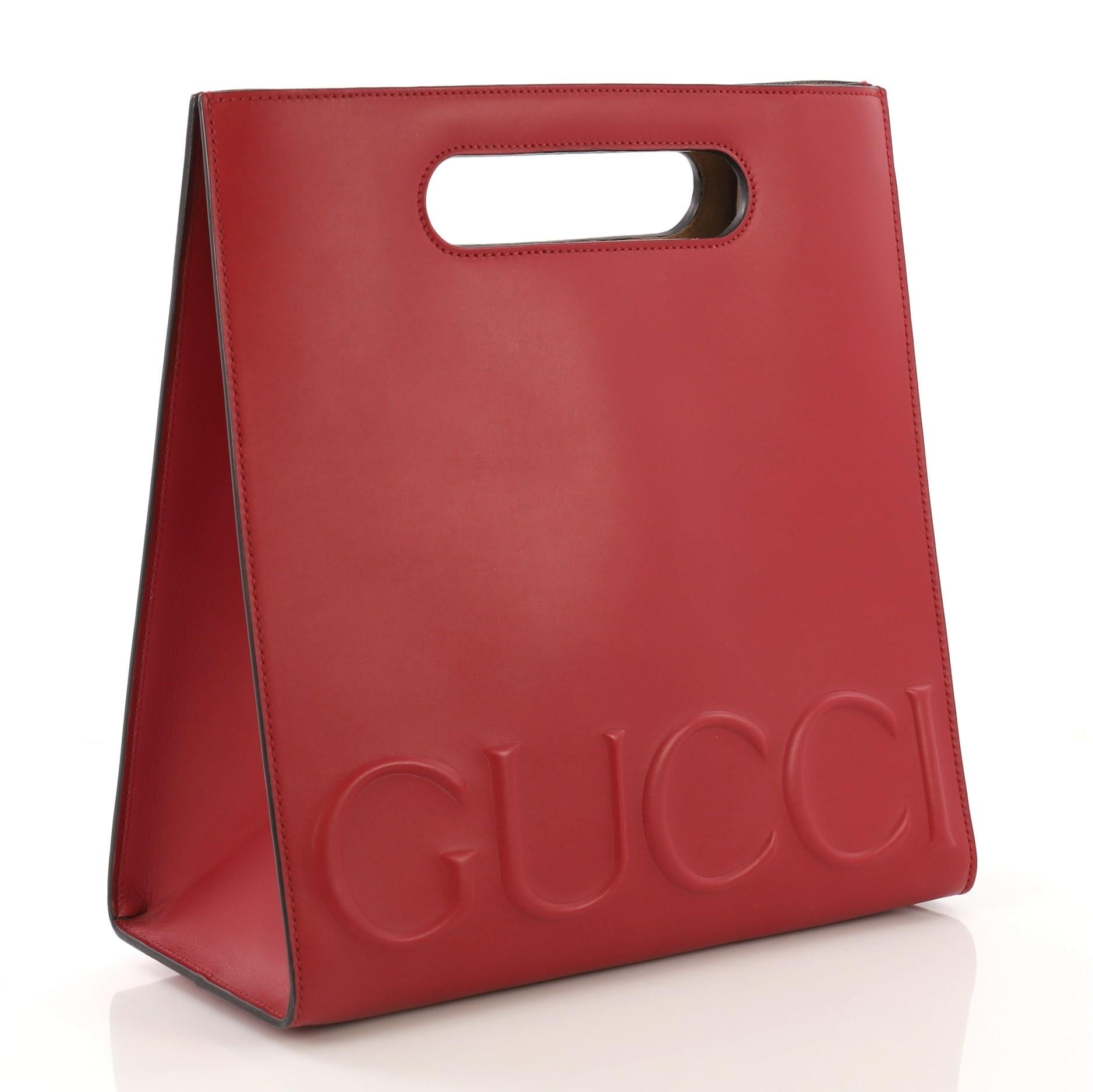 This Gucci XL Tote Leather Small, crafted from red leather, features cut out top handles and embossed Gucci logo. Its wide open top showcases a beige microfiber interior. **Note: 

Estimated Retail Price: $2,490
Condition: Excellent. Faint scuffs
