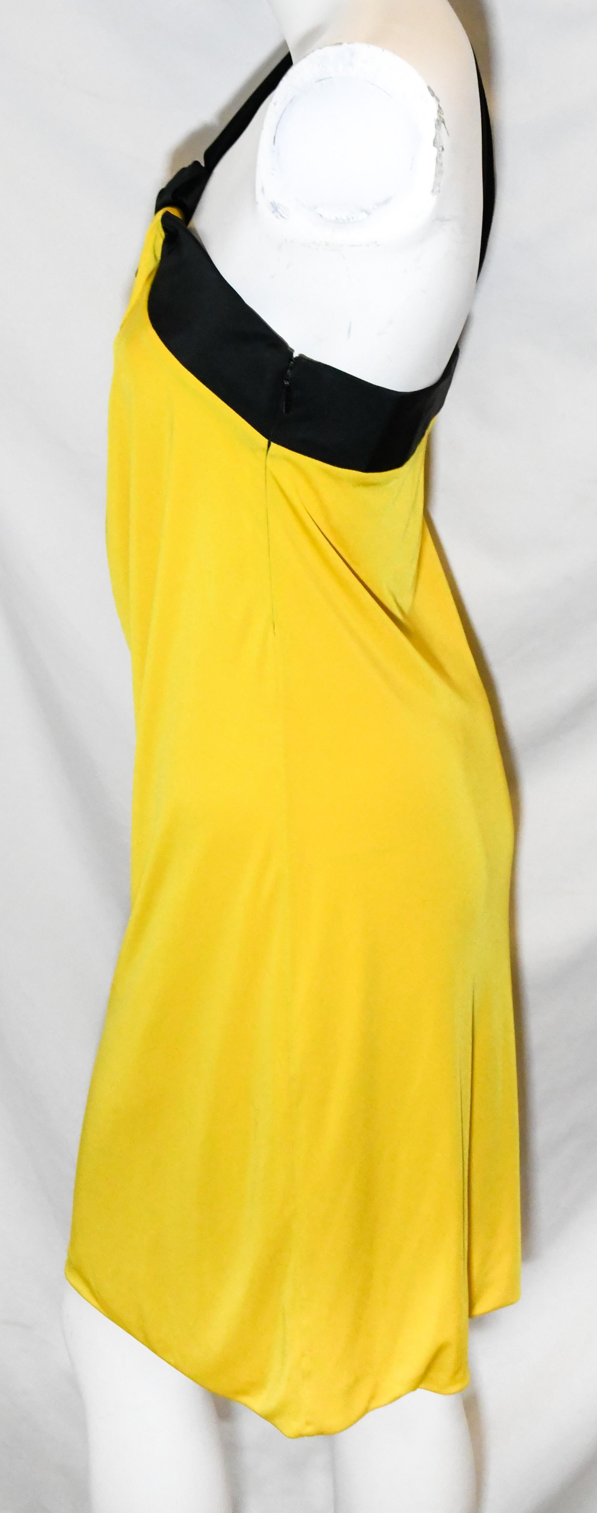 Gucci yellow and black one shoulder wide strap cocktail dress lined in yellow silk.  Dress is decorated with black band across the bust and up one shoulder.  The dress is softly gathered at front.  The dress includes a long zipper, at back, for
