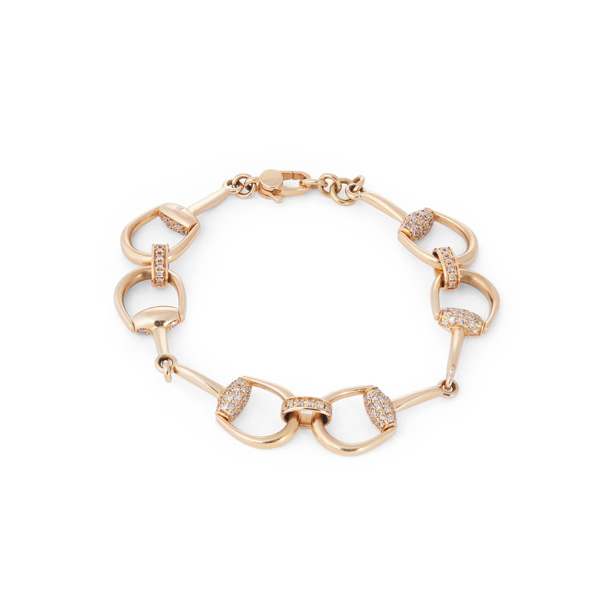 Authentic Gucci bracelet crafted in 18 karat yellow gold.  Featuring three sets of interlocking horsebit shaped links that are pave set with approximately 1.05 karats of round brilliant cut diamonds.  The bracelet measures 7 3/4 inches in length and