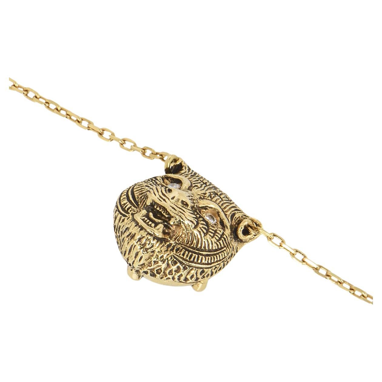 A versatile Gucci 18k yellow gold pendant from the Le Marche des Merveilles collection. The front of the pendant features a feline head with 2 round brilliant cut diamond eyes, totalling 0.02ct and on the reverse is a round carved onyx inset with a