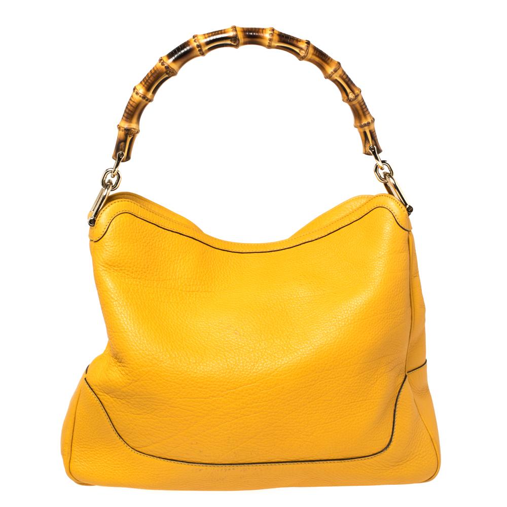Invest in this timeless creation from the house of Gucci. Sophisticated and elegant, this yellow shoulder bag is made from leather into a slouchy and relaxed shape. This stylish bag comes with a bamboo handle and a detachable shoulder strap for