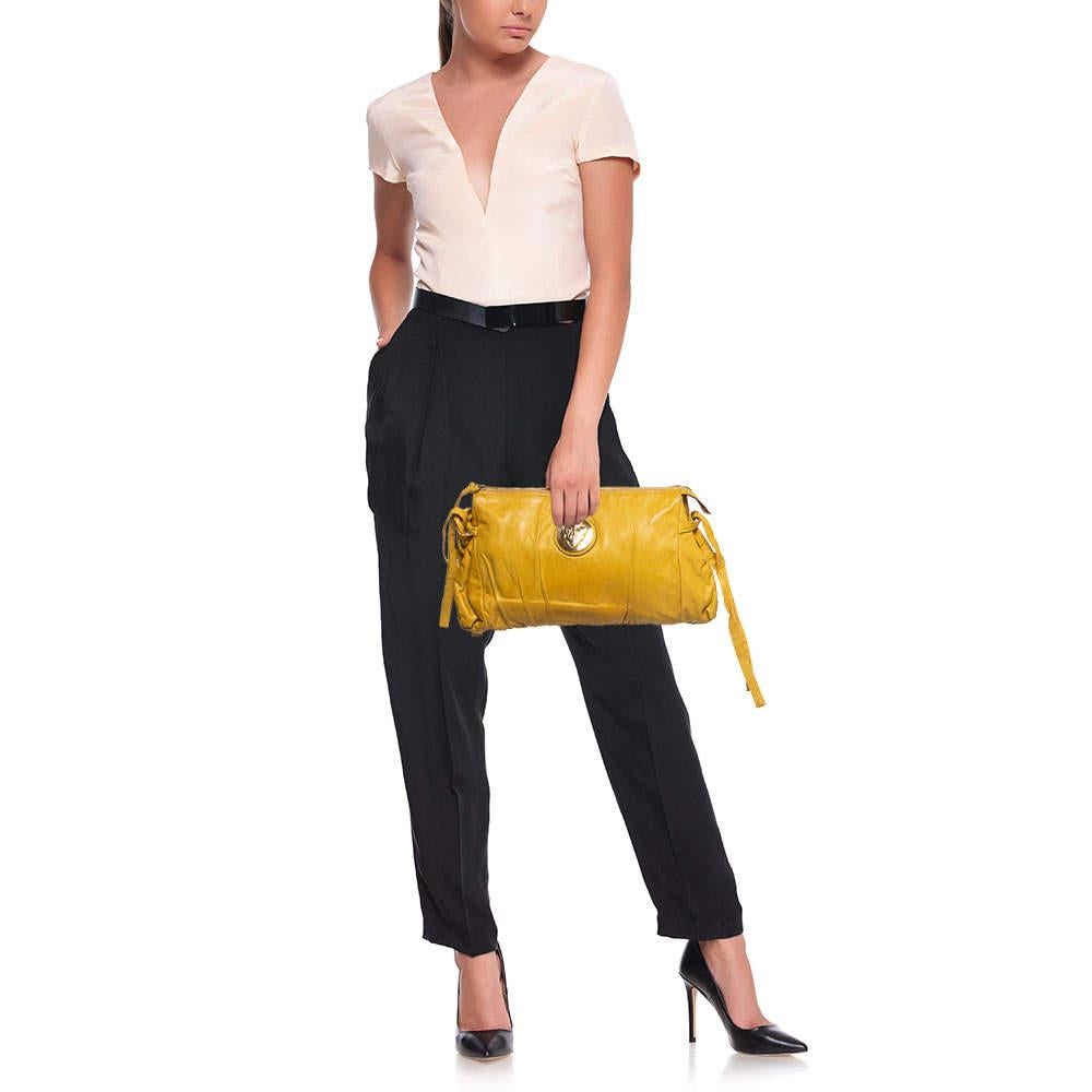 This Gucci clutch is built to suit all your stylish ensembles. Crafted from leather, it has a yellow shade and a zipper which secures a nylon-lined interior. The clutch is complete with the signature Hysteria emblem on the front and a