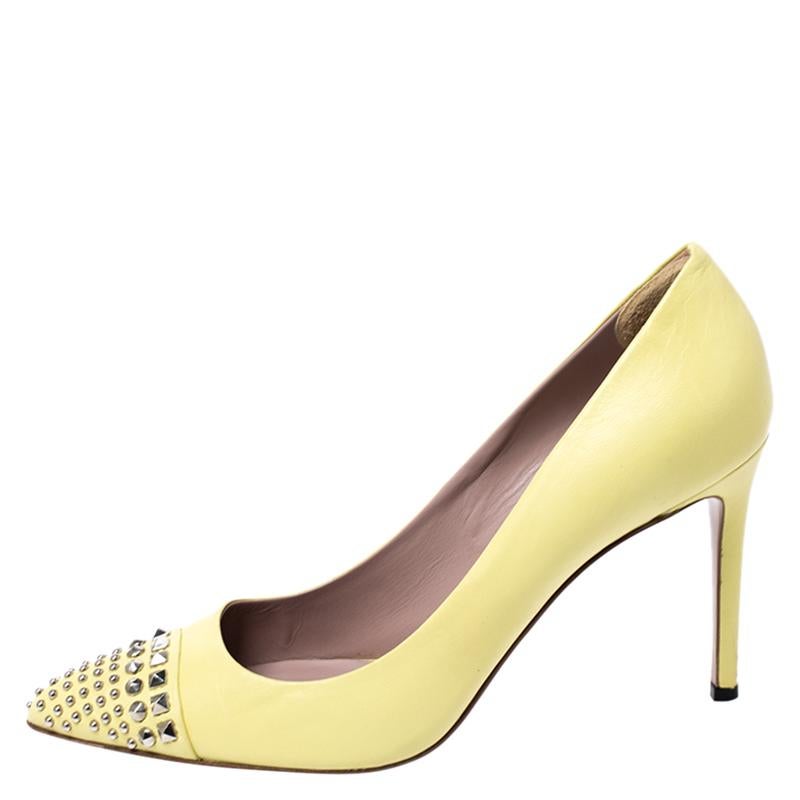 Look chic and make an elegant style statement in this pair of pumps from the house of Gucci. They are crafted from leather featuring stud embellishments on the pointed toes, high heels, and a stunning shade of yellow. Add a touch of sophistication