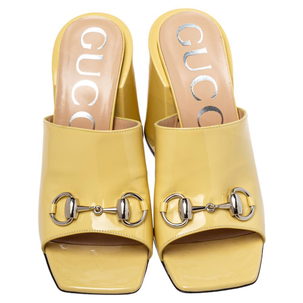 Featuring a chic, minimalist design, these Lexi slide sandals from Gucci are easy to style. Yellow patent leather uppers showcase the signature Horsebit while chunky block heels and square toes form a distinctive outline. Their simple design pairs