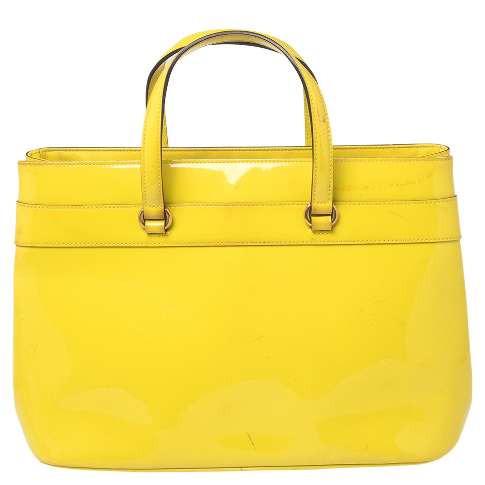 Diese Bright Bit Tote von Gucci beweist, dass Stil auch in einfachen Dingen stecken kann. Diese hübsche gelbe Tasche aus Lackleder verfügt über ein stoffgefüttertes Inneres, zwei obere Griffe und einen langen abnehmbaren Schulterriemen. Sie ist mit