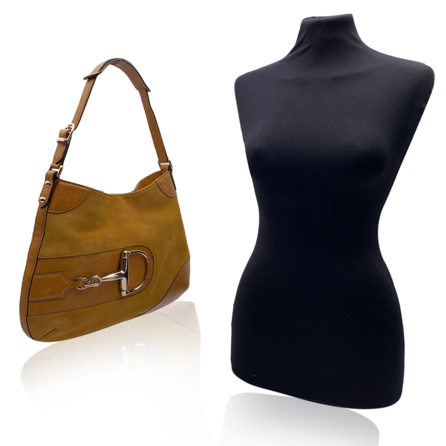 Gucci 'Hasler' Hobo Bag in yellow suede and leather with gold metal horsebit detail on the front. Magnetic button closure on top. Canvas lining. 1 side zip pocket inside. 'GUCCI - Made in Italy' tag inside (with serial number on its