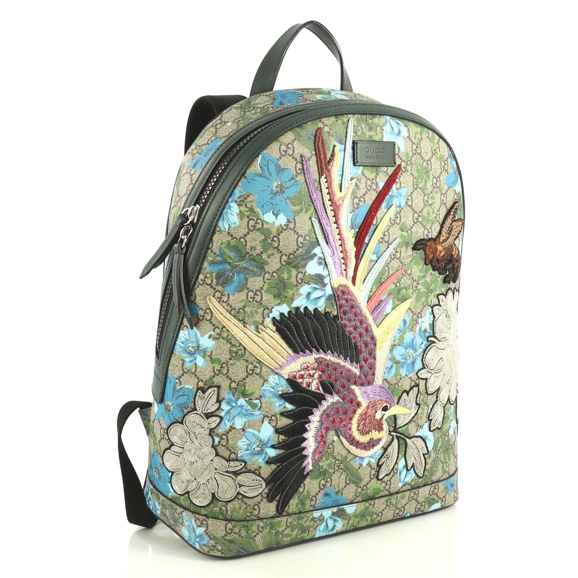 This Gucci Zip Backpack Blooms Print Embroidered GG Coated Canvas Medium, crafted from brown embroidered GG coated canvas, features adjustable shoulder straps, top handle, and silver-tone hardware. Its zip closure opens to a brown microfiber