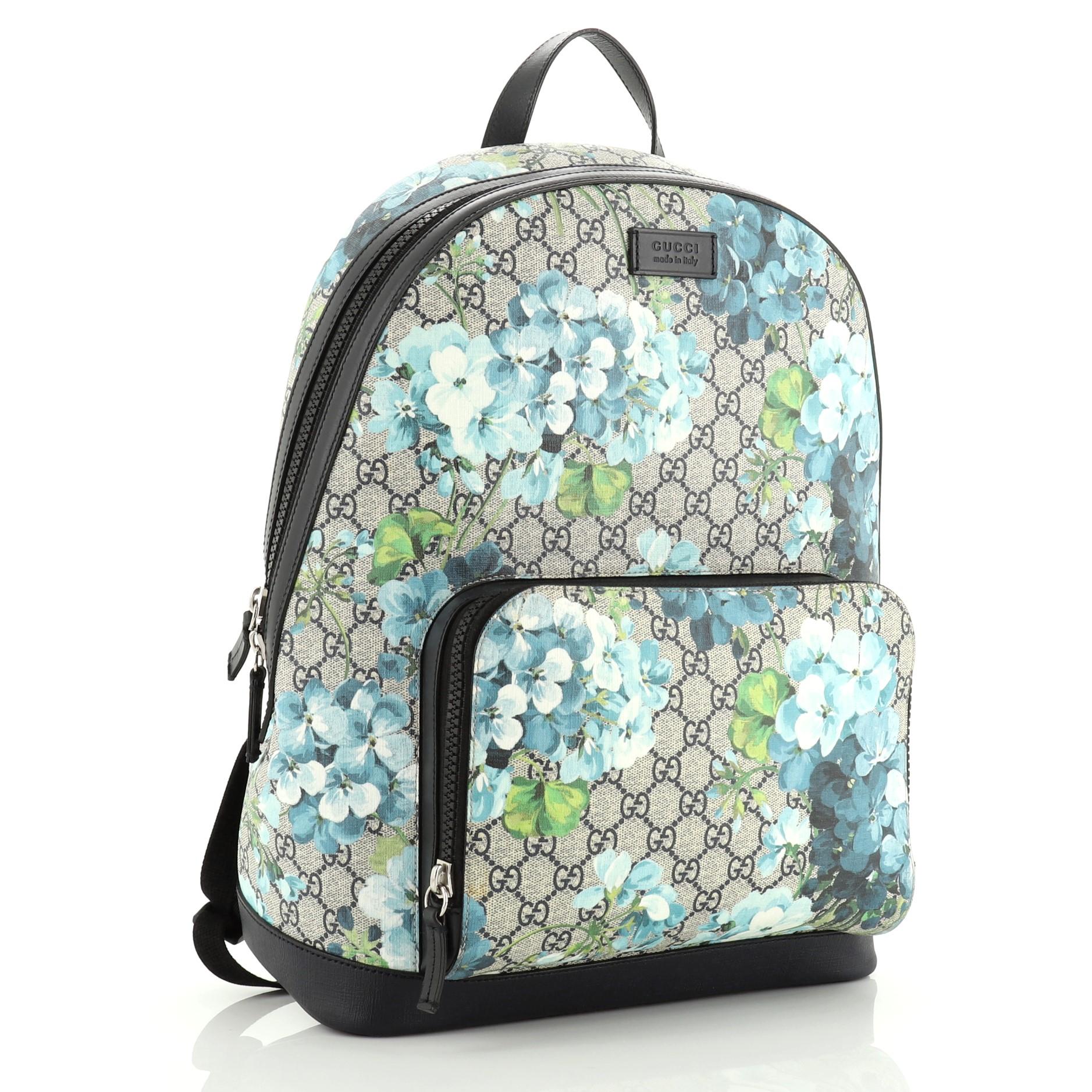This Gucci Zip Pocket Backpack Blooms Print GG Coated Canvas Medium, crafted from blue GG coated canvas with blooms print, features adjustable padded shoulder straps, top handle, exterior front zip pocket and silver-tone hardware. Its zip closure