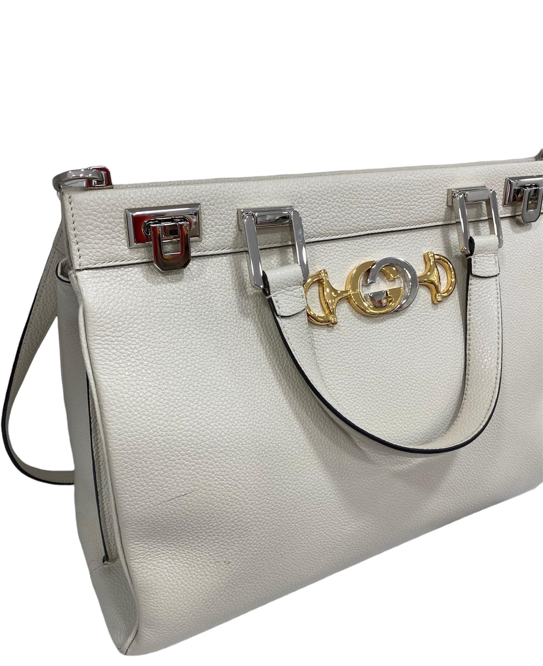 Gucci hand bag, Zumi line, made of white leather with silver hardware and gold.

Equipped with an opening with double interlocking closure, internally covered in Bordeaux suede, very large.

Equipped with a double leather handle, a central internal
