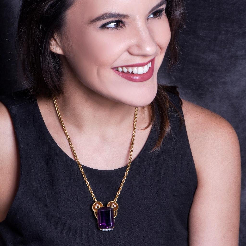 This conspicuous Retro pendant necklace is an authentic piece of jewelry designed and manufactured by the Swiss Horologists & Jewelers Gueblin. This opulent amethyst and pearl pendant exposes a magnificent intense purple color Rectangular cut