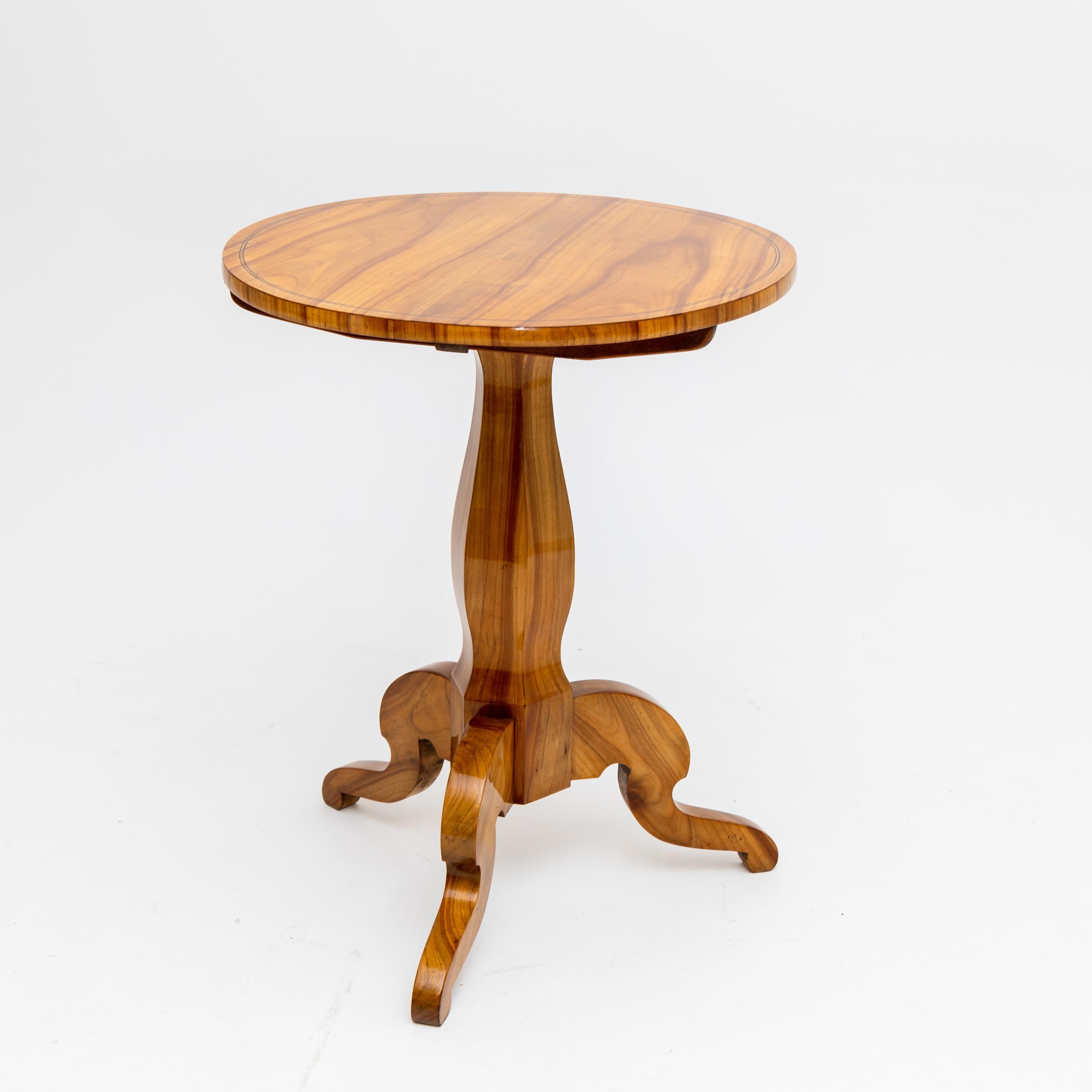 Side table standing on three-legged stand with folding table top and radial thread inlays.