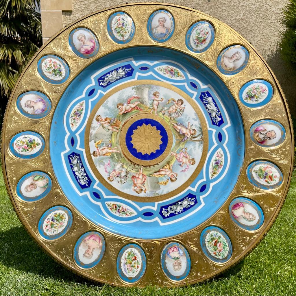 Exceptional Louis XVI style pedestal table with circular Sèvres style porcelain top with in the center a scene representing Putti in play in a chiseled gilt bronze border. This bronze border is inlaid with oval porcelain medallions representing