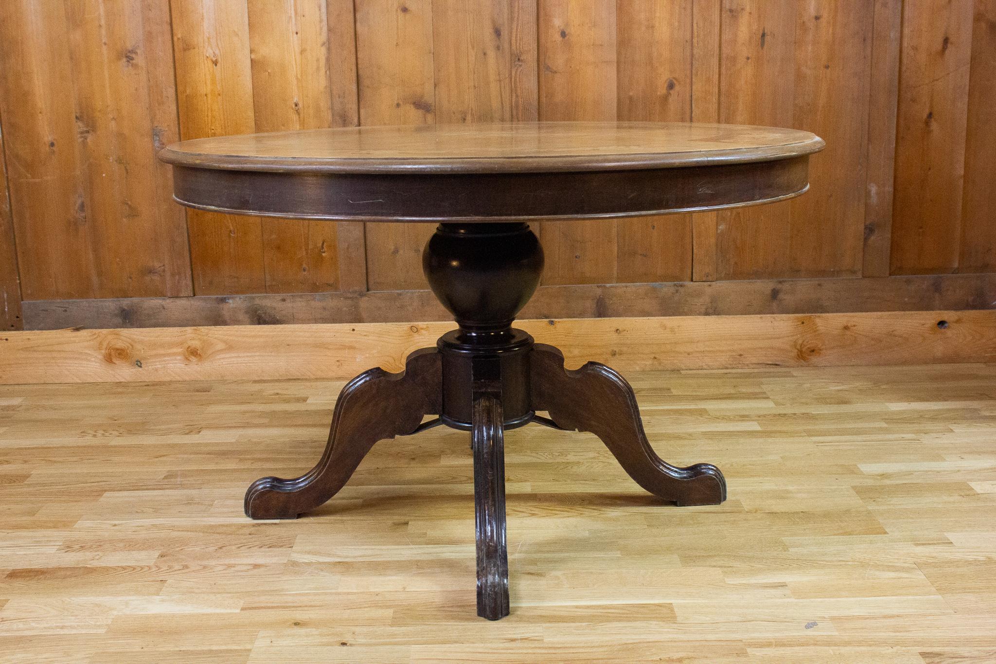 Very nice Louis-Philippe style center table from the 20th century. The body is in black while the elegant light brown top is inlaid with floral and plant motifs.