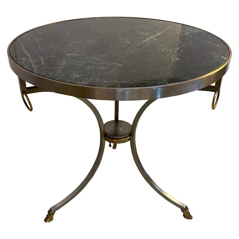 This stylish Louix XVI style gueridon tables dates to the 1960s-1970s and is very much in the manner of pieces created by Maison Jansen. The frame is fabricated in steel and brass and a verdi green marble top.