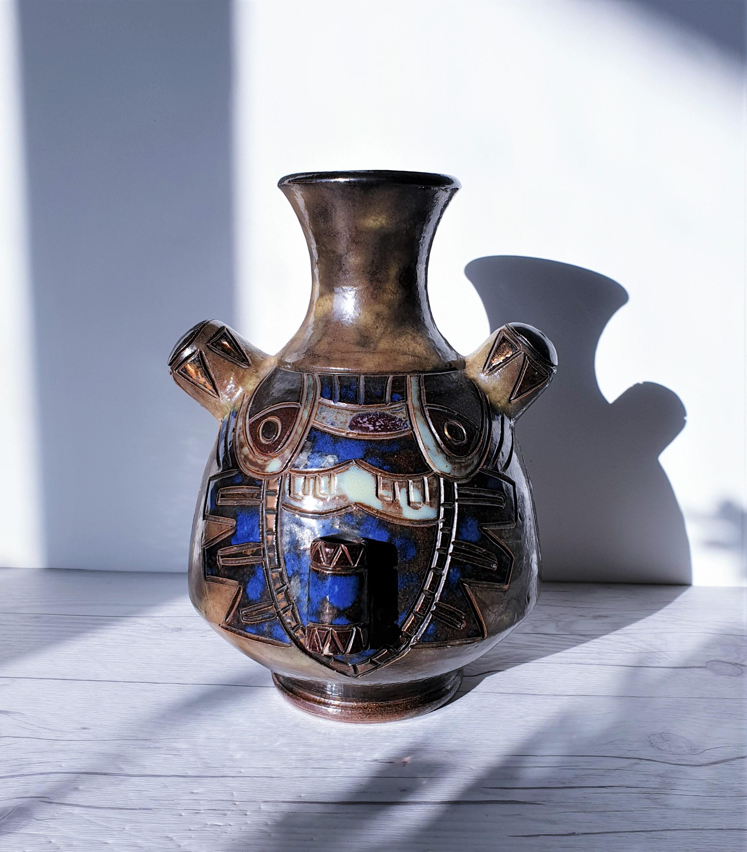 This stunning work of art by Roger Guerin hints at Northwest Pacific tribal symbolism with the abstract bear and jaybird décor. This hand-thrown vase is an outstanding example of his work, featuring unusual spouts and additions to its shape as well