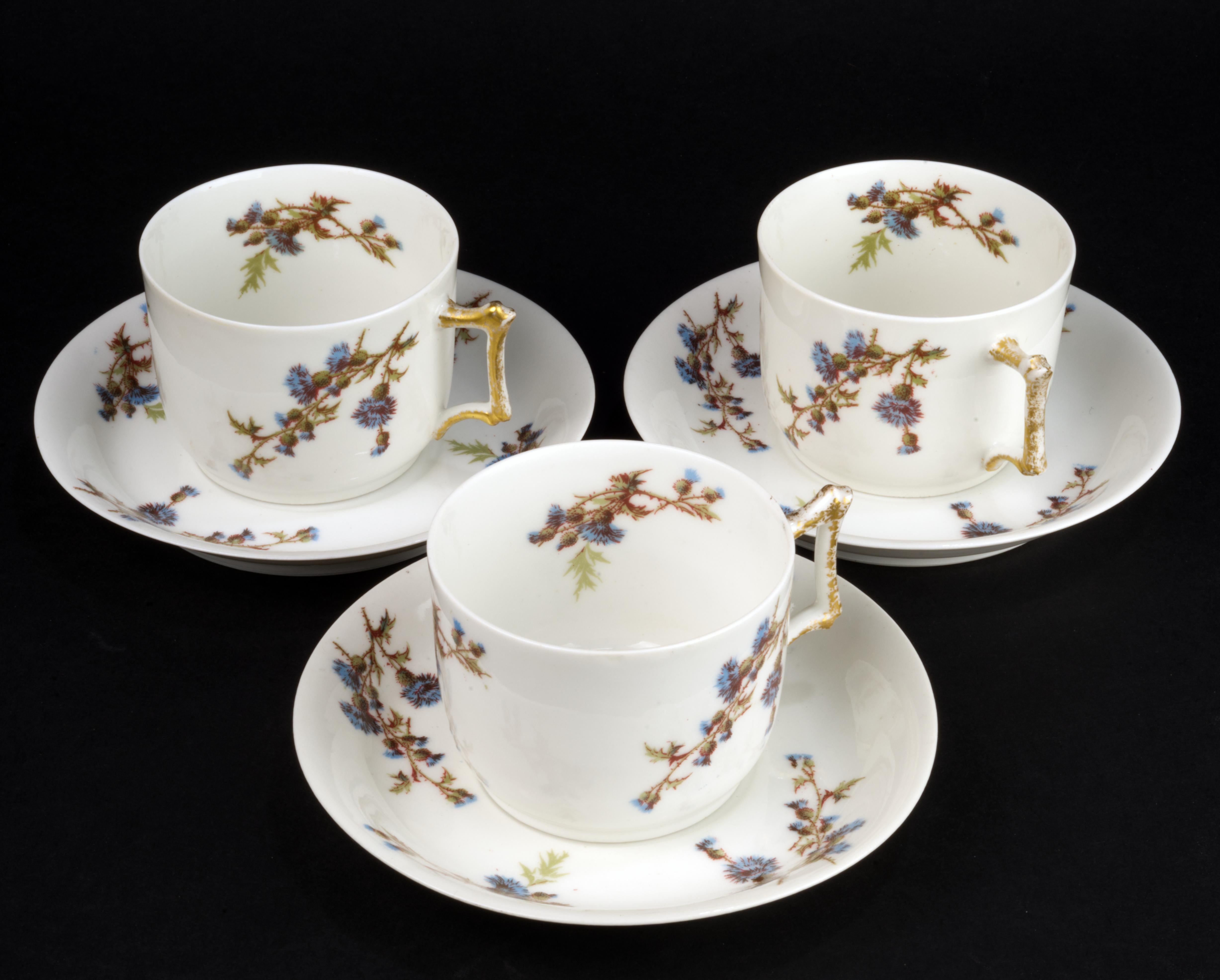 
Set of 3 cups and 3 saucers by Guerin &Co was made of fine, semi-transparent bone china in Limoges, France. The set is hand decorated in Victorian style with ornamental blue and brown thistle flowers motifs on white background and gold trim on cups