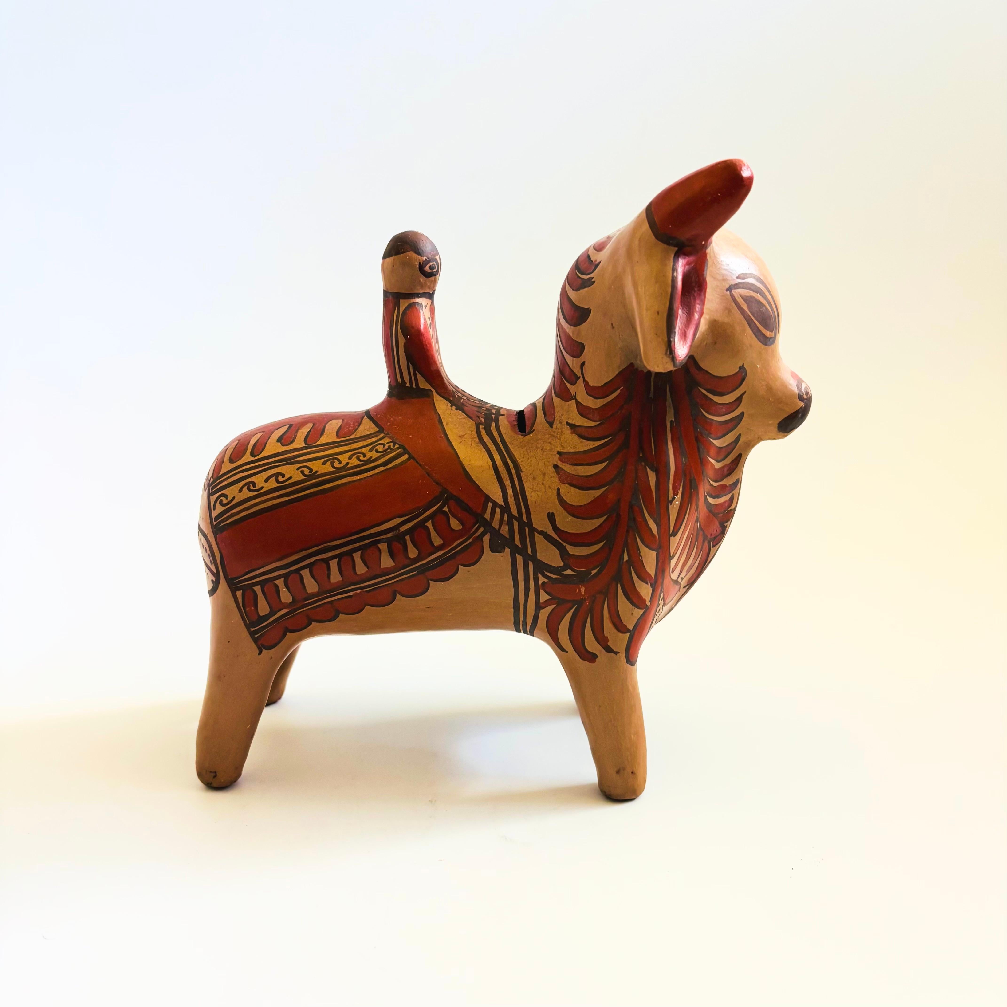 Una banca d'epoca in ceramica d'arte popolare messicana. Realizzato a mano a Guerrero, in Messico. La banca ha la forma di un toro con un cavaliere e presenta bellissimi disegni in terracotta dipinti a mano. C'è una fessura per le monete nella parte