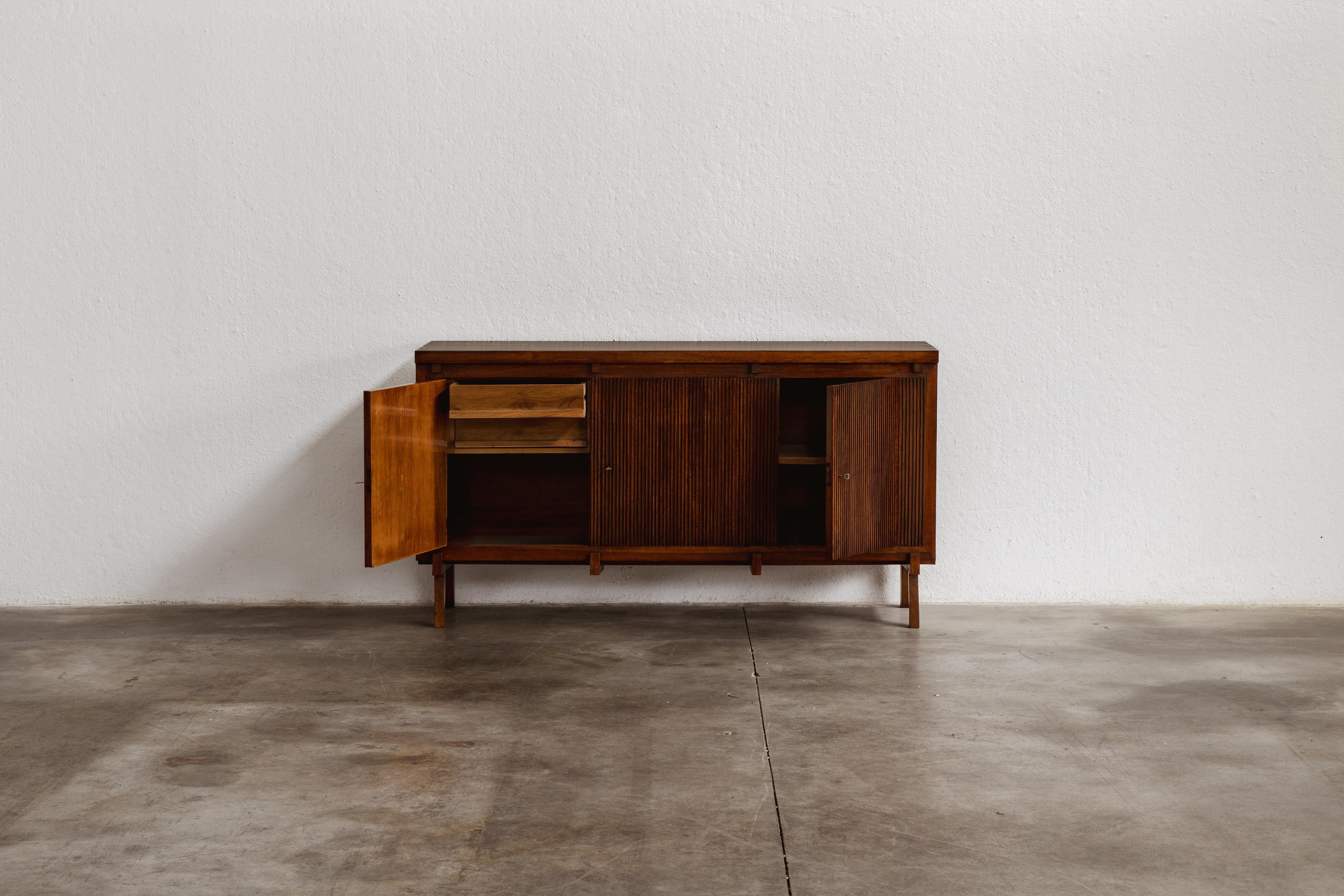 Credenza Gugielmo Ulrich, legno, Italia, 1950 

Disegnata da Guglielmo Ulrich nel 1950, questa credenza di metà secolo riflette il passaggio dal suo precedente stile neoclassico al rigore modernista. Costruita in legno massiccio, presenta tre ante a