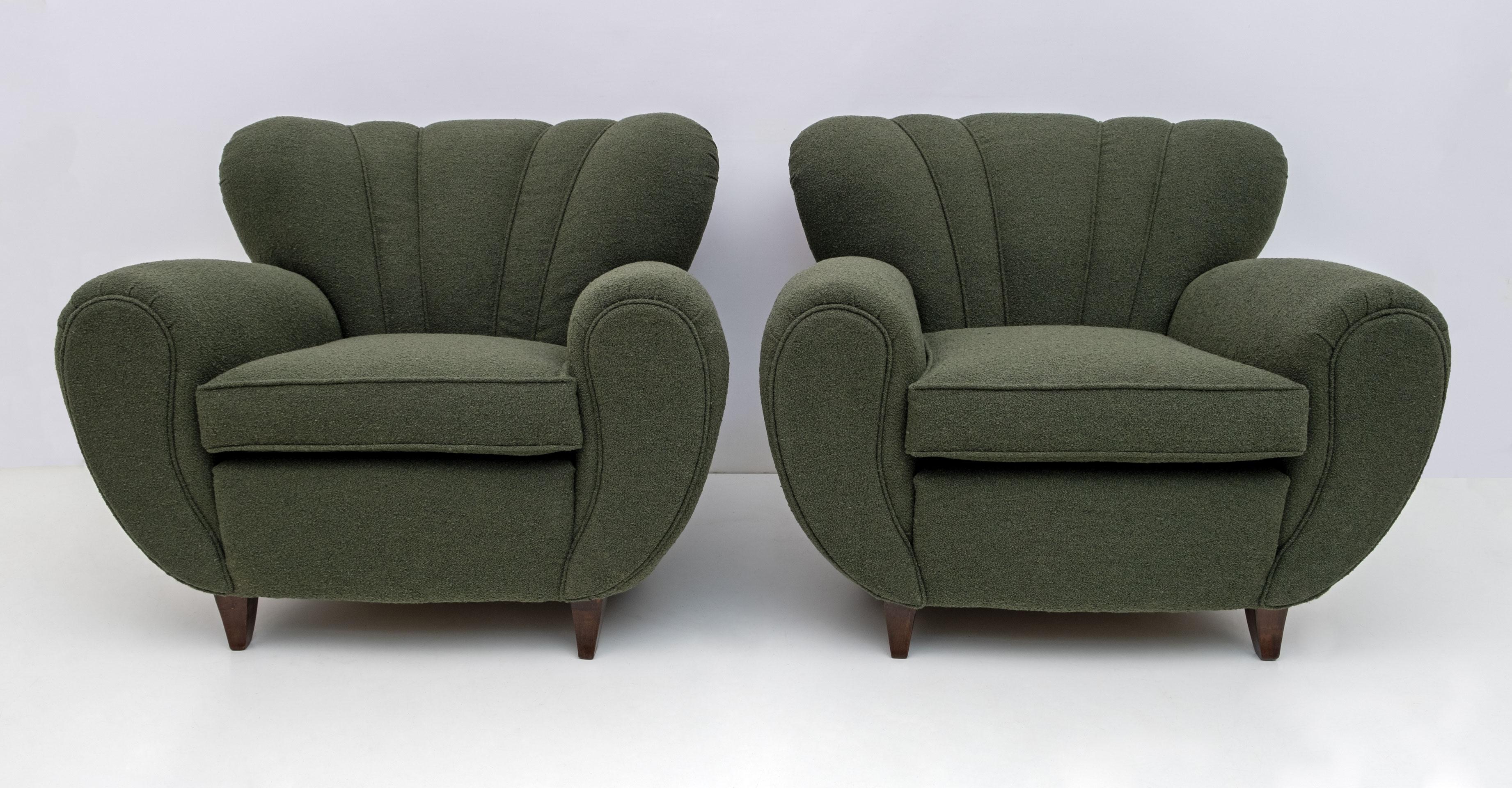 Pair of Italian sculptural armchairs designed attributed Guglielmo Ulrich, very comfortable. Recently covered in green Bouclè, finished with a border of the fabric itself, in order to accentuate the curved shapes. The tapered and curved feet in