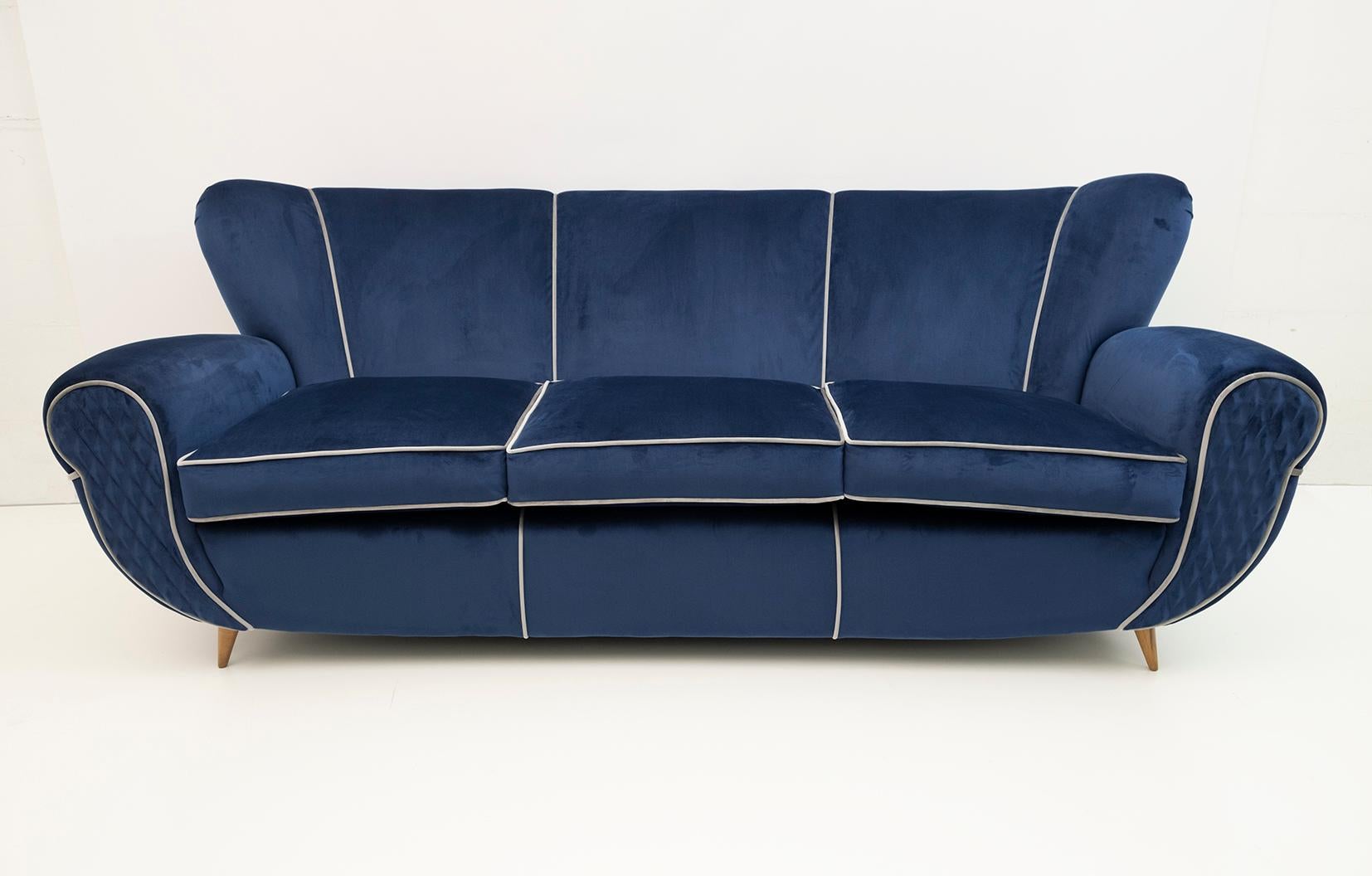 A large Italian sculptural sofa designed by Guglielmo Ulrich, very comfortable. Recently upholstered in light blue velvet with a light gray velvet border, in a minimalist way, which accentuates the curved shapes. The tapered and curved feet in beech