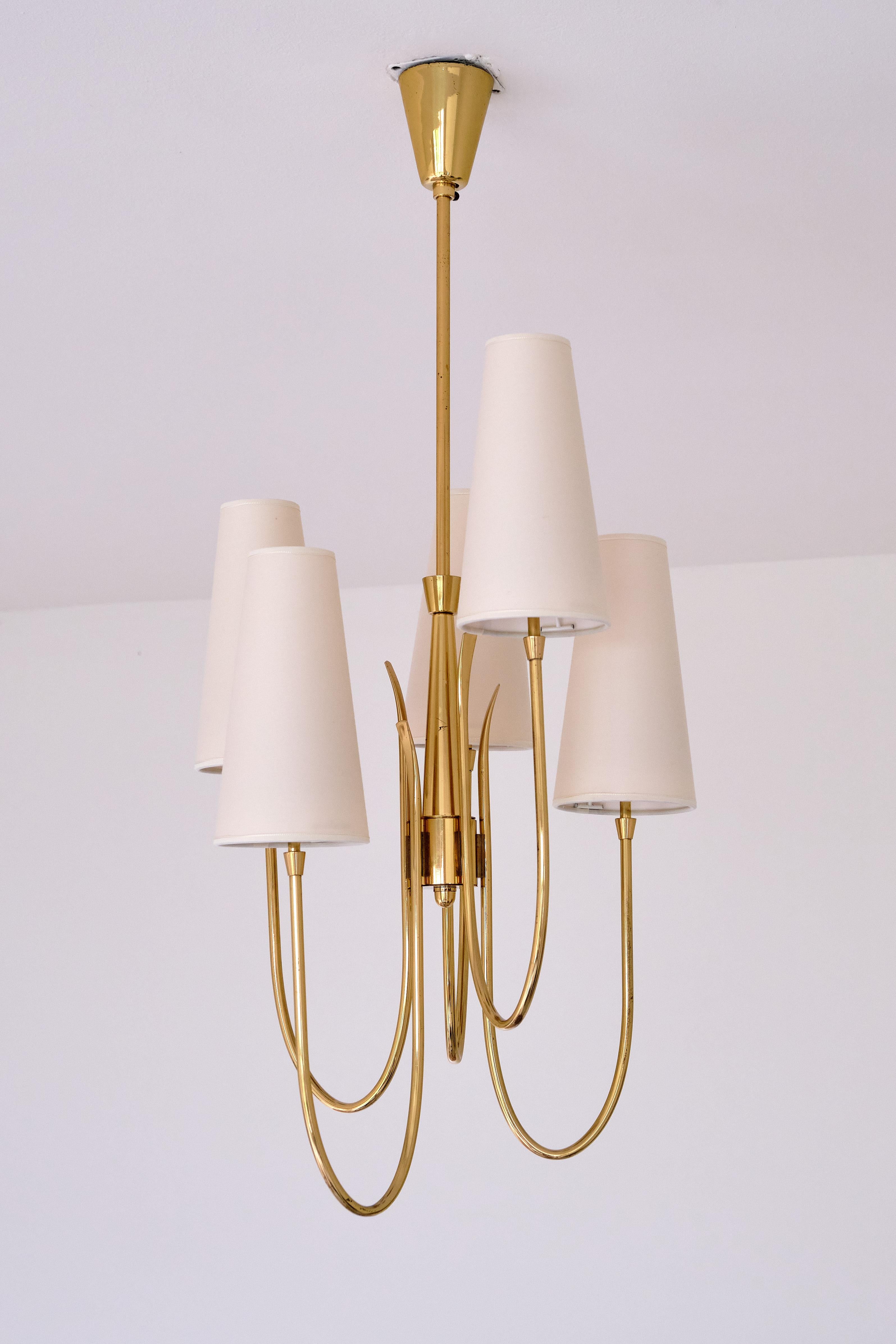 This striking, tall chandelier was produced in Italy in the late 1940s, with the design attributed to Guglielmo Ulrich. This brass fixture consists of five arms of different heights which gives the design a distinct and elegant appearance . The