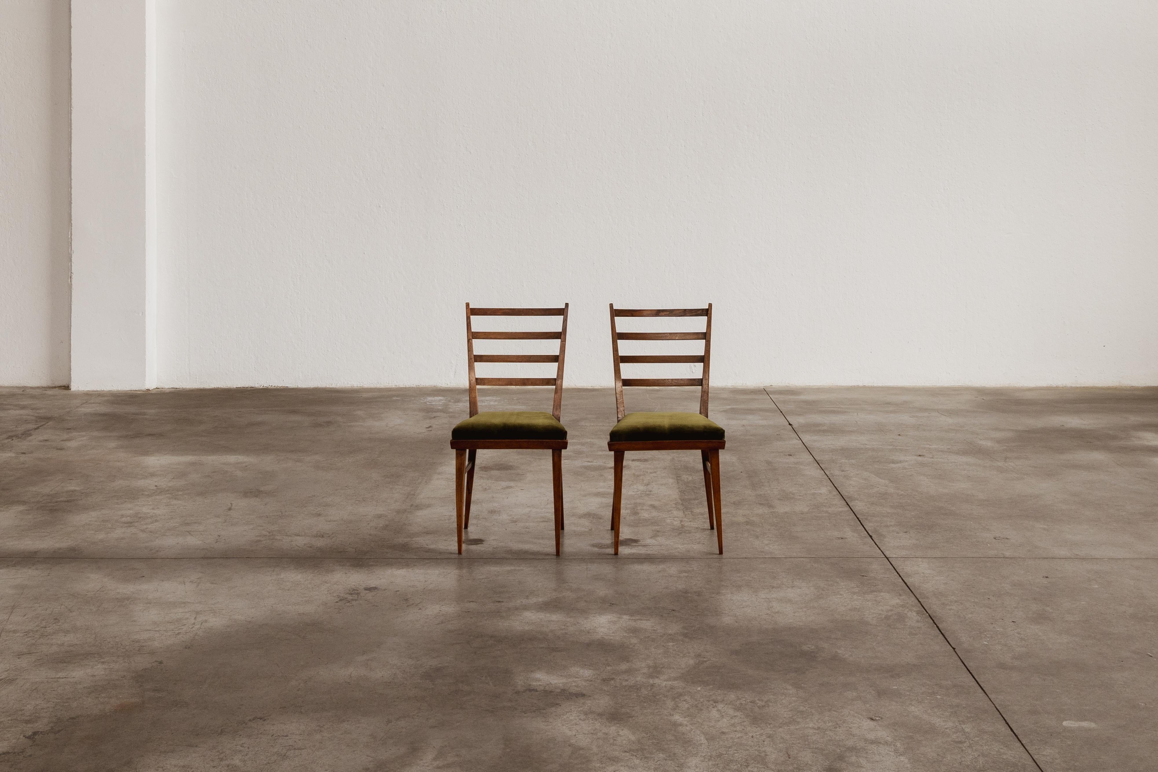 Guglielmo Ulrich dining chairs for Saffa Milano, green velvet and wood, 1950, set of two

These 1950 dining chairs by Guglielmo Ulrich exemplifies the structural elegance of Italian mid-century design. Crafted in solid walnut, the frame integrates a