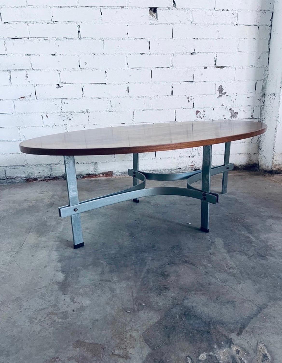 Mid-century Italian coffee or cocktail table designed in the 1950s by Guglielmo Ulrich with an oval solid wood top and metal legs. 

Its elegant proportions and the combination of metal and bent steel are reminiscent of the designs of Carlo Graffi