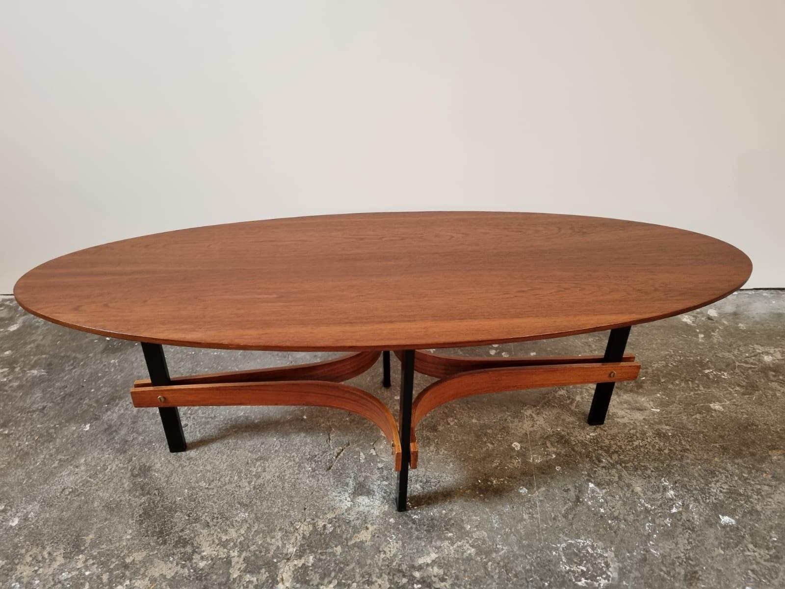 Elegante tavolino da caffè o cocktail in teak italiano della metà del secolo scorso, disegnato negli anni '50 da Guglielmo Ulrich, con piano ovale in legno massiccio di teak e gambe in metallo laccato nero. Le sue proporzioni eleganti e la