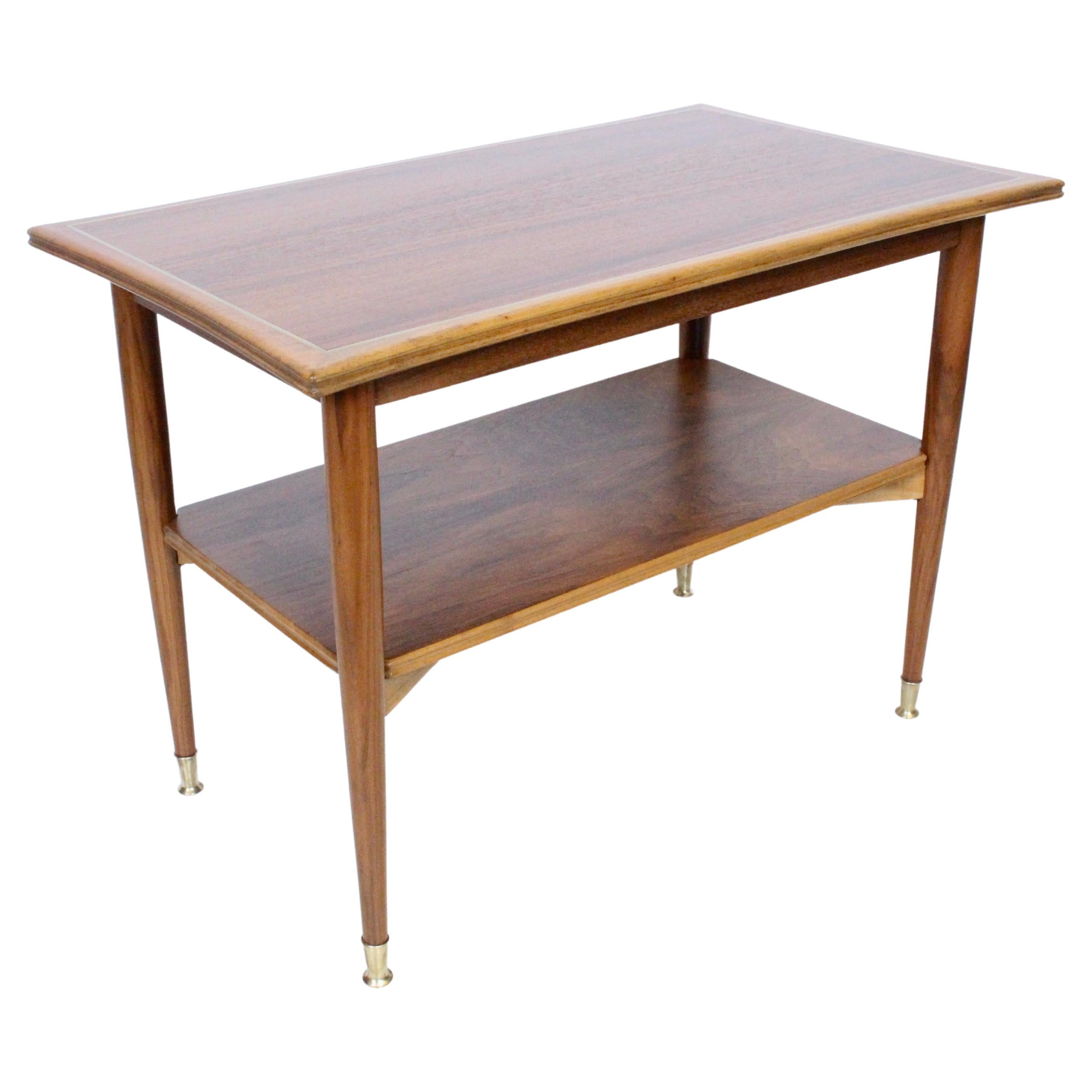 Italian Modern Guglielmo Ulrich style flared edge two tier palisander and fruitwood rimmed coffee table with brass inlay, 1950's. Featuring a rectangular banded Palisander veneer surface, framed with smooth flared Fruitwood edges, and inlaid Brass.