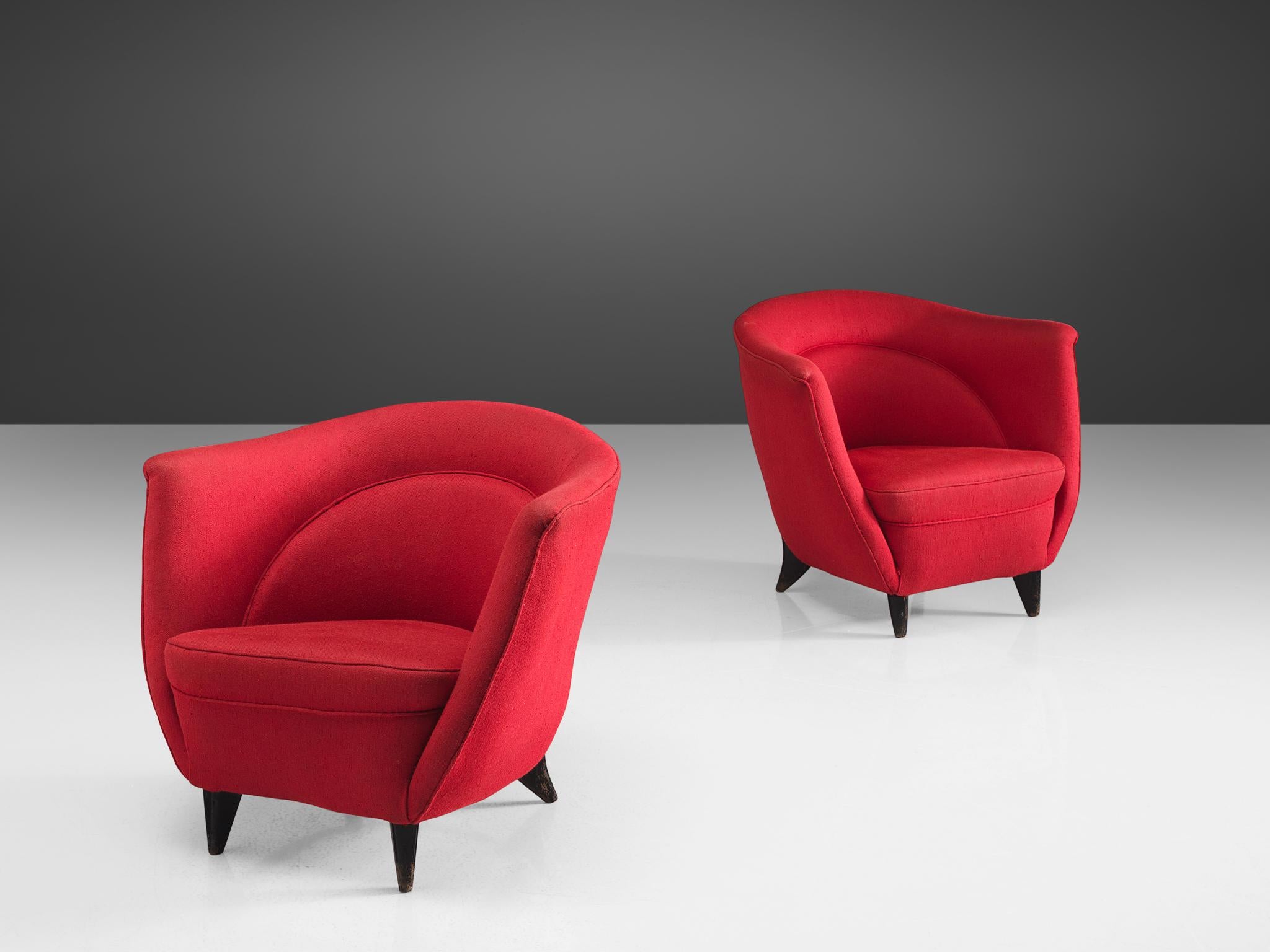 Guglielmo Veronesi, lounge chairs, red fabric, wood, Italy, 1950s.

These red chairs by Veronesi feature a high back with high armrests that are almost the same height as the back. As a result, this chair works as a type of shell that embraces the