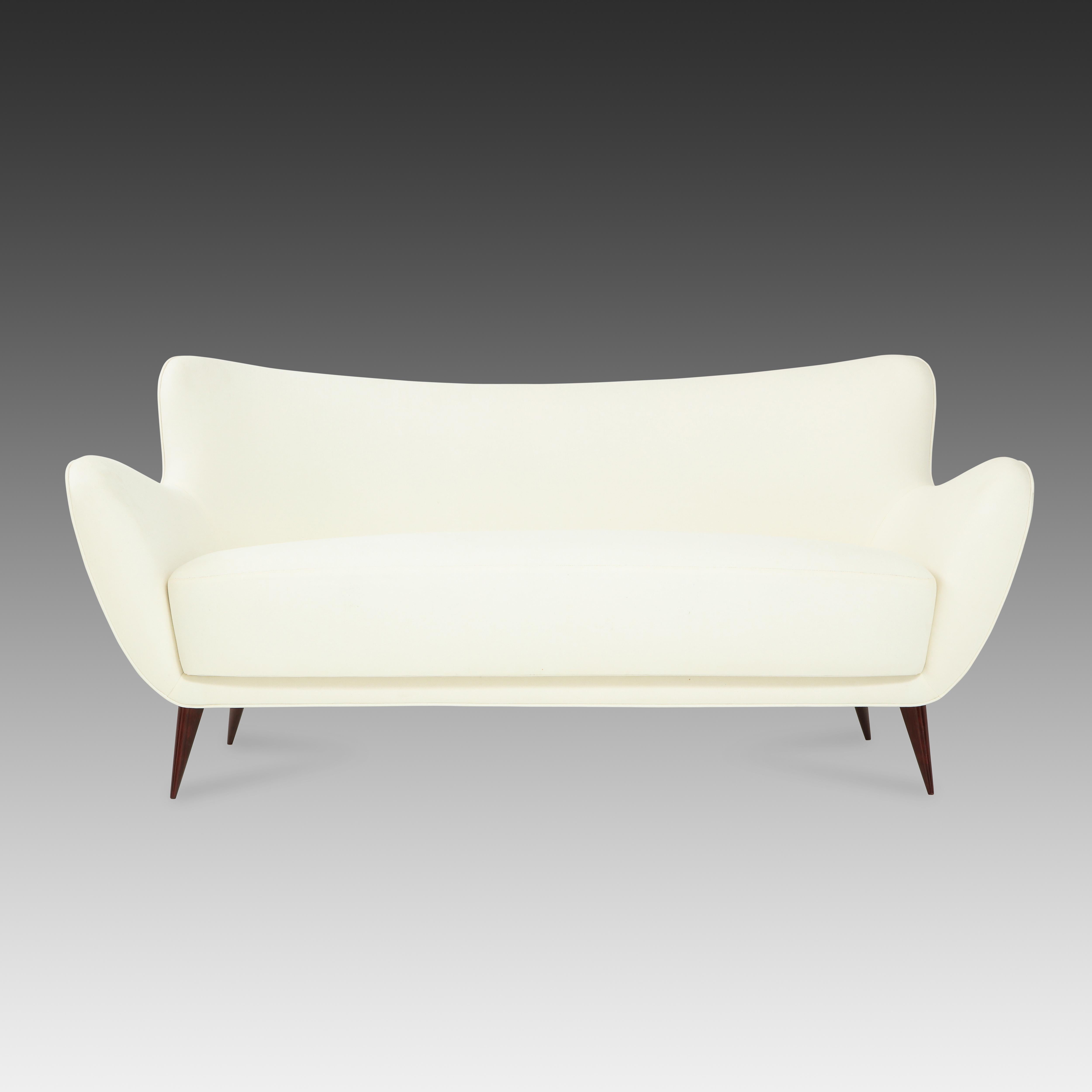 Guglielmo for I.S.A. Bergamo elegant and sculptural 'Perla' sofa with slightly curved back and gently outstretched arms ending in signature sharply tapered walnut legs, Italy, 1950s. 
Fully restored and newly reupholstered in off-white cotton linen