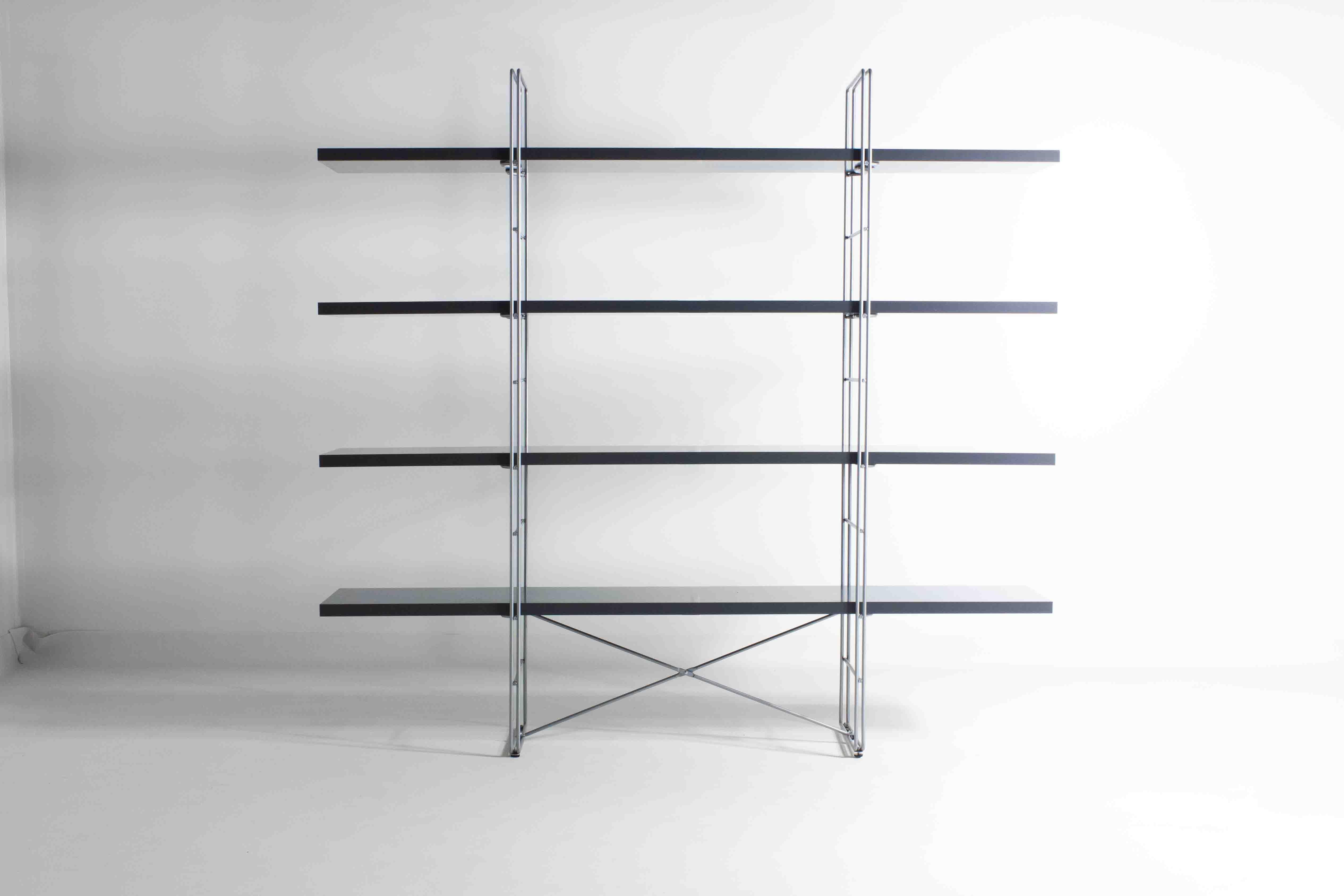 The grey GUIDE shelving unit with its wire sides and coloured shelf edges fit nicely into the urban furnishing style of the 1980s. The shelving unit came about as a cousin to the modern MOMENT sofa, which had a steel mesh underframe inspired by